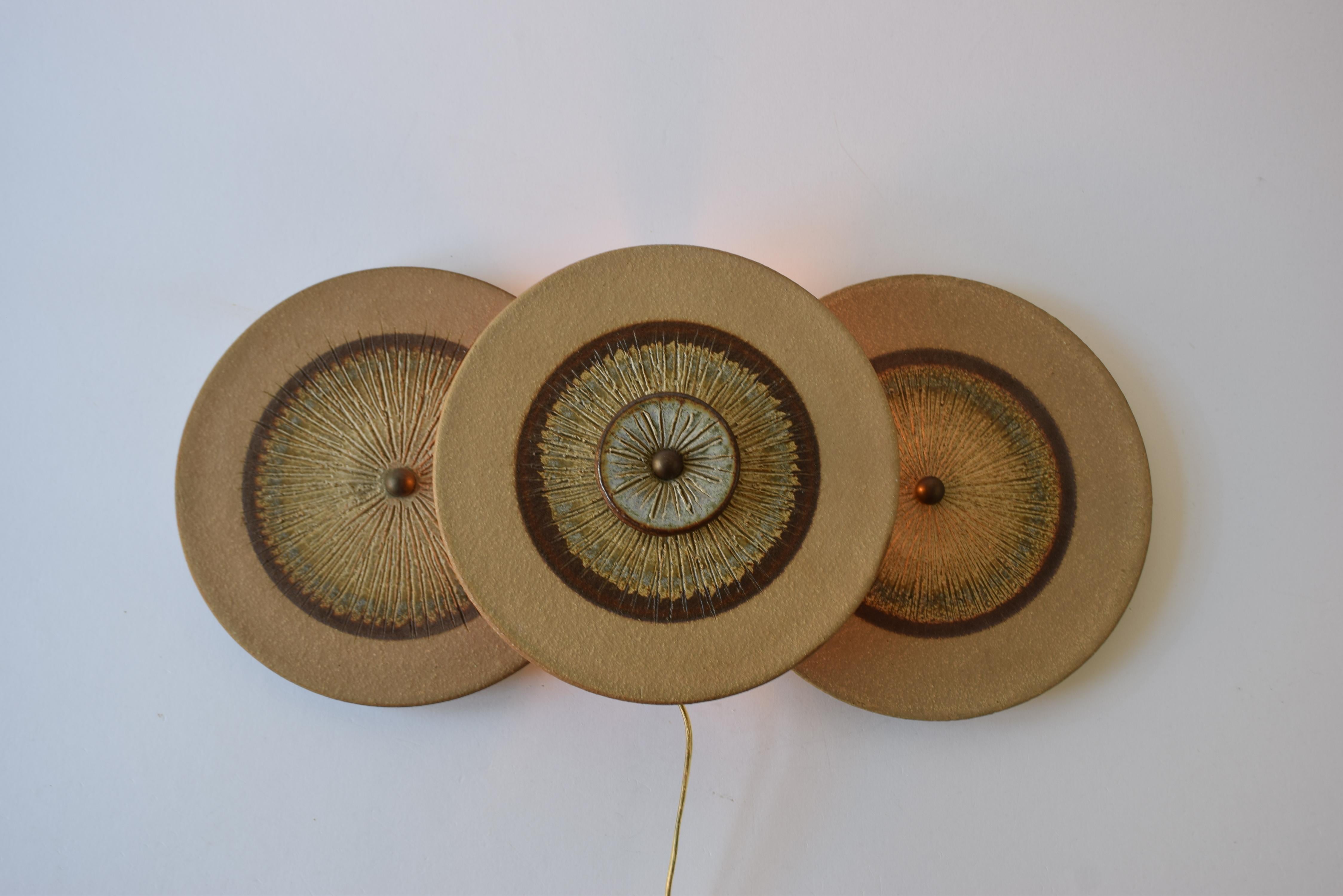 Large stylish Danish midcentury wall sconce.
The lamp is made the acknowledged pottery Søholm on Bornholm and the design is attributed to Noomi Backhausen & Poul Brandborg. Made ca. 1960s or 1970s

The lamp consists of overlapping circular disks