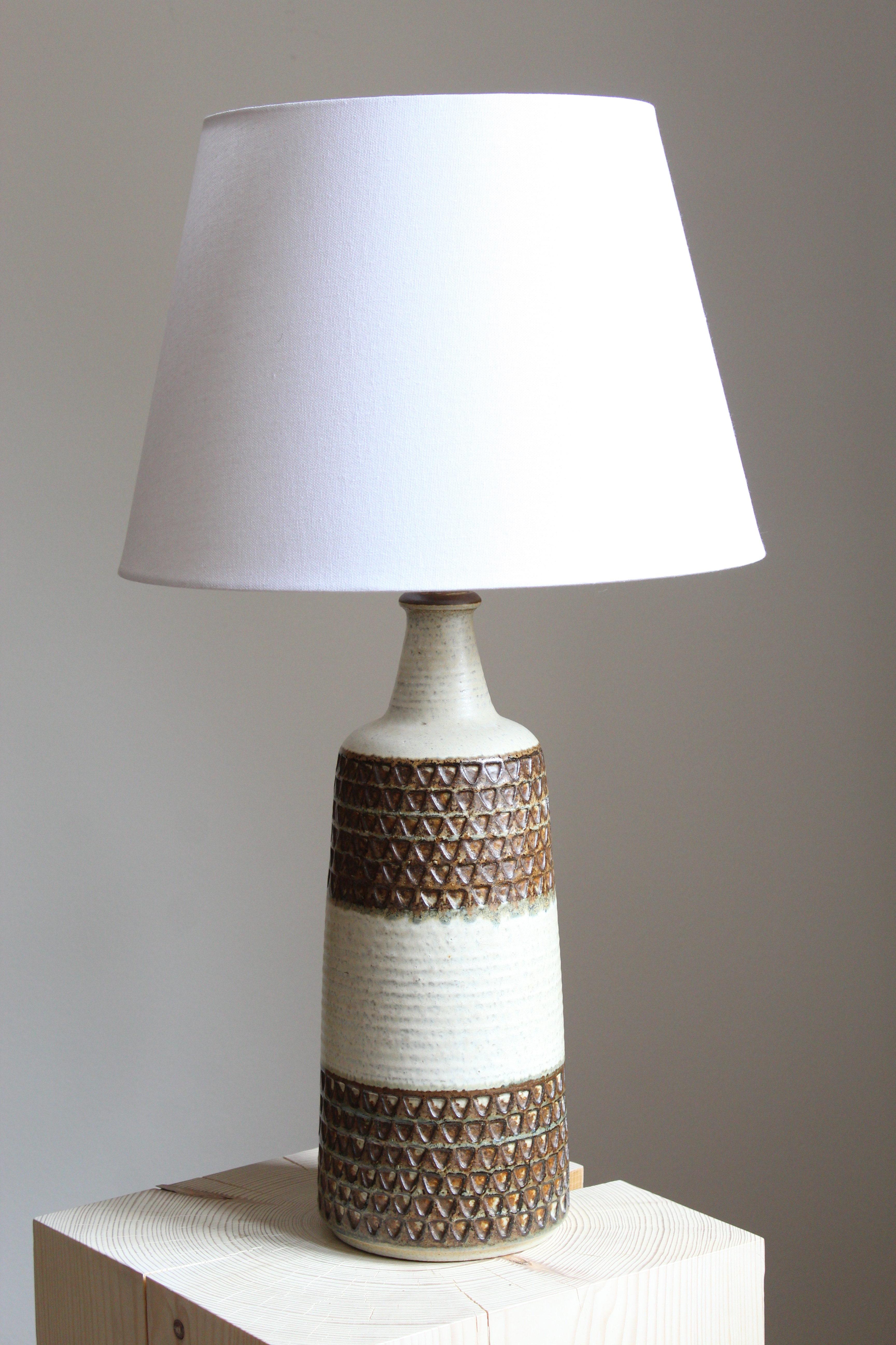 A large table lamp produced by Søholm Keramik, located on the island of Bornholm in Denmark. Features a highly artistic glazed decor. 

Sold without lampshade. Stated dimensions exclude the lampshade.

Glaze features brown-white colors.

Other