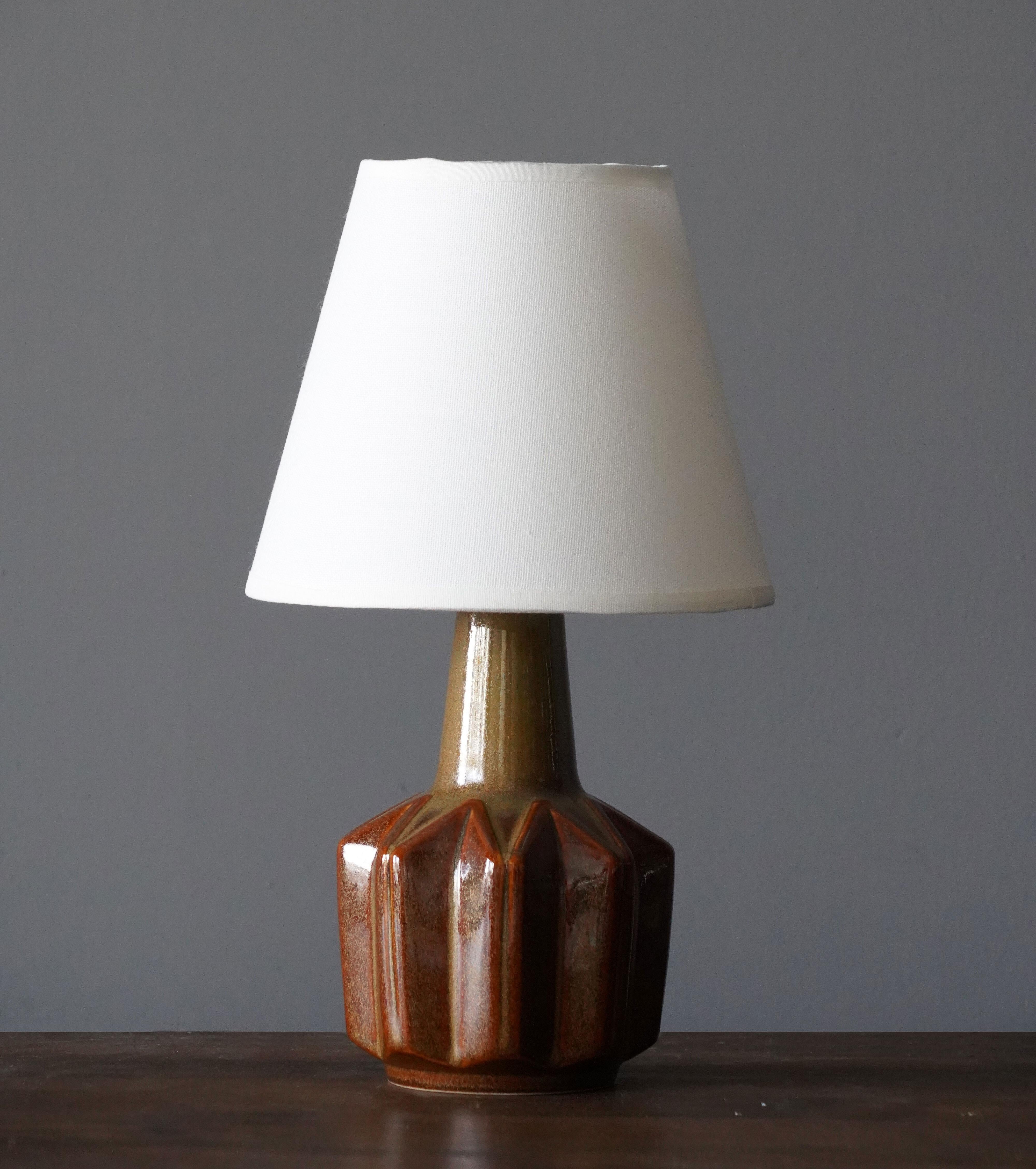 A small table lamp produced by Søholm Keramik, located on the island of Bornholm in Denmark. 

Lampshade is attached for reference and are not included in the purchase. Measured without lampshade.

Glaze features brown-beige-green colors.

Other