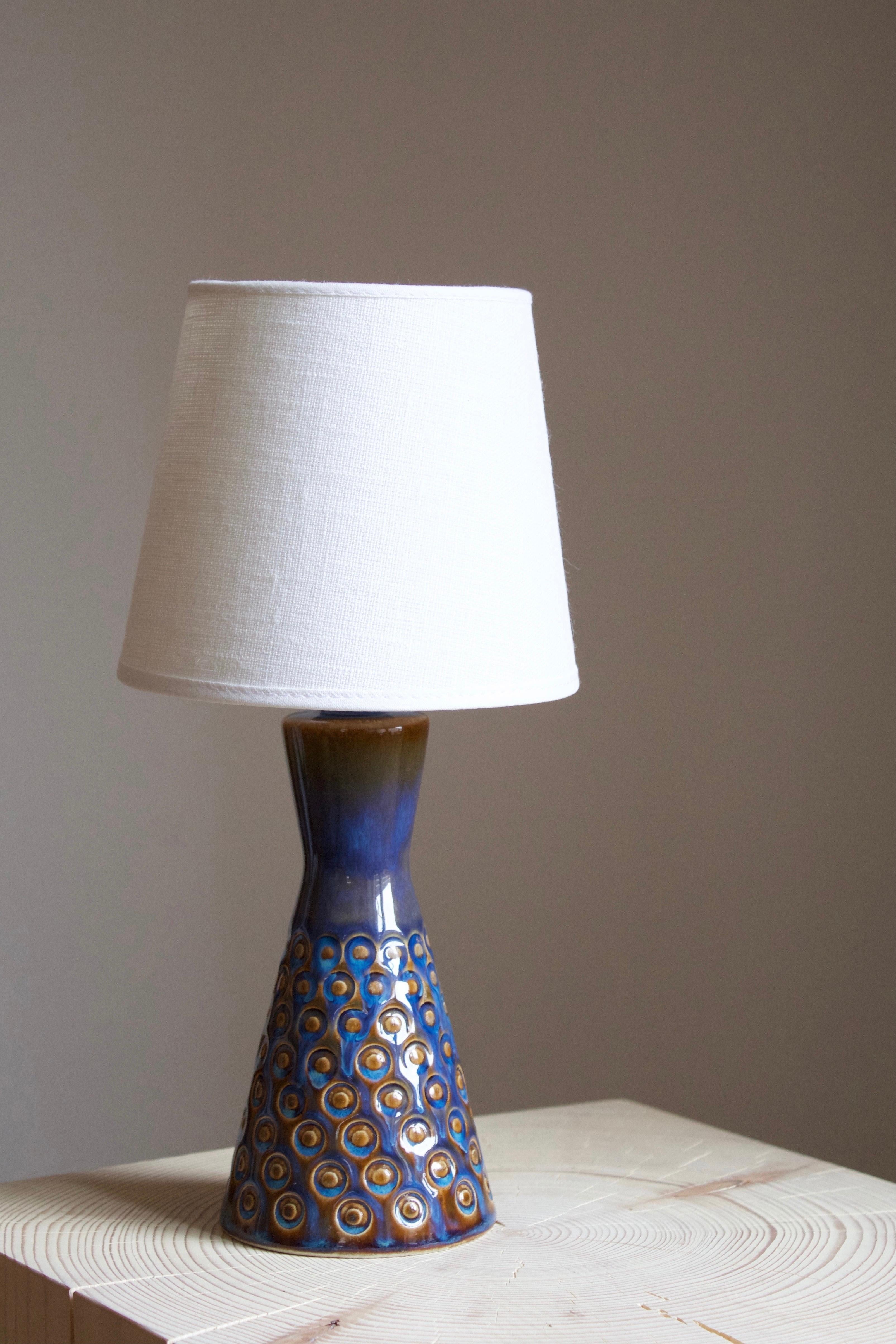 A small table lamp produced by Søholm Keramik, located on the island of Bornholm in Denmark.  Sold without lampshade.

Glaze features brown-blue colors.

  
