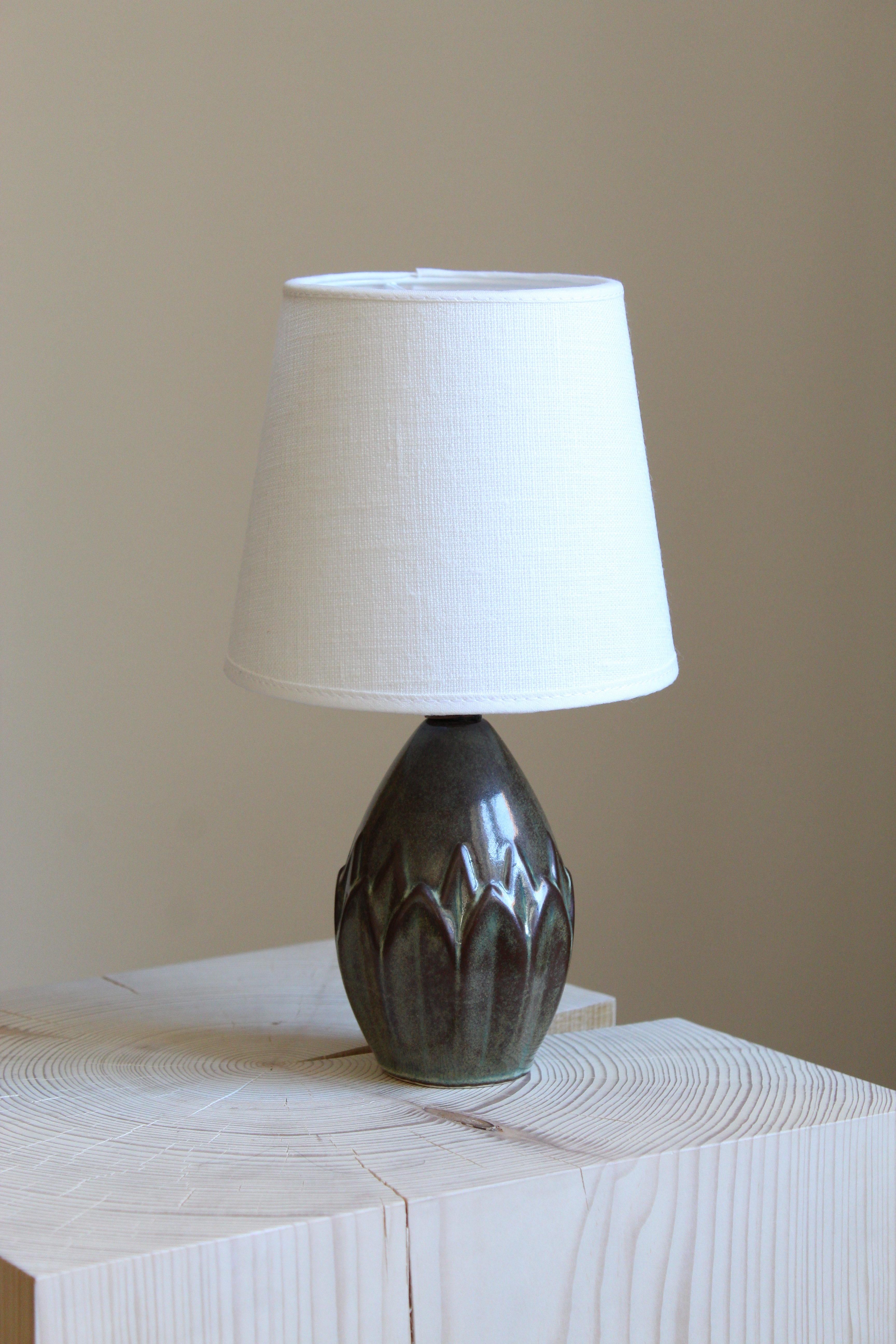 A small table lamp produced by Søholm Keramik, located on the island of Bornholm in Denmark. Features a highly artistic green / grey / brown glazed decor. Brand new linen lampshade.
  