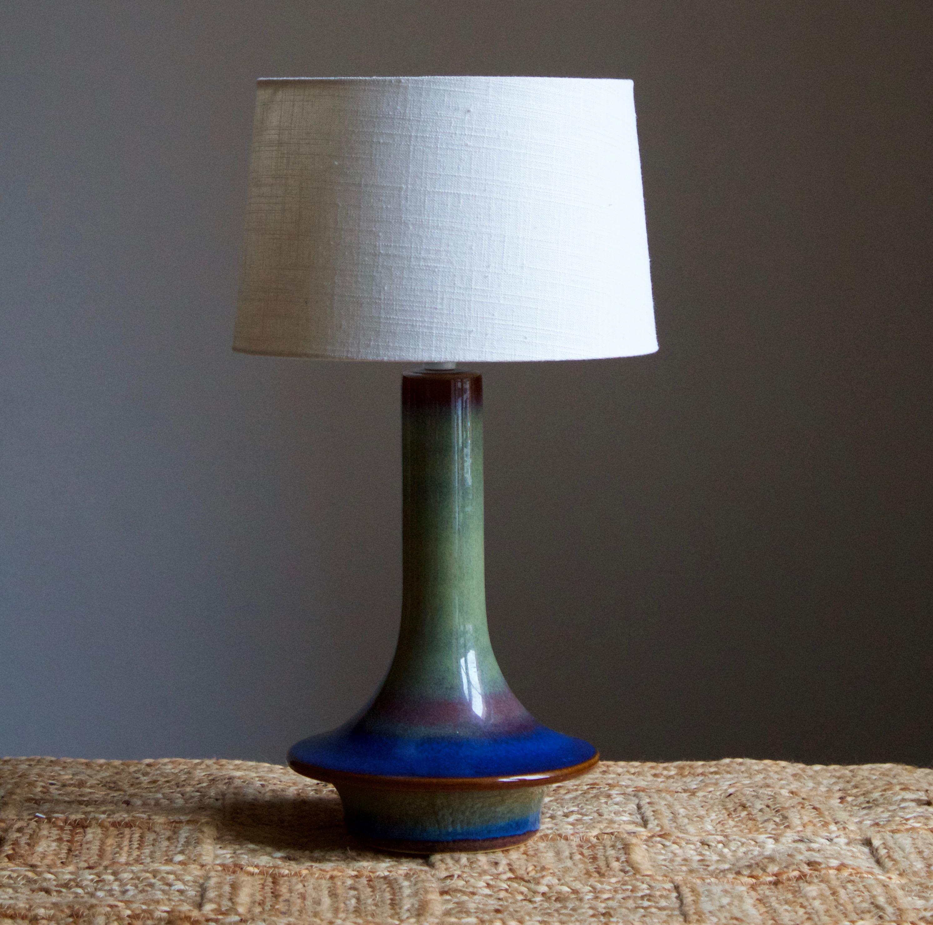 A table lamp produced by Søholm Keramik, located on the island of Bornholm in Denmark. Features a highly artistic blue and green glaze.

Sold without lampshade. Stated dimensions exclude the lampshade.

Other designers of the period include Axel