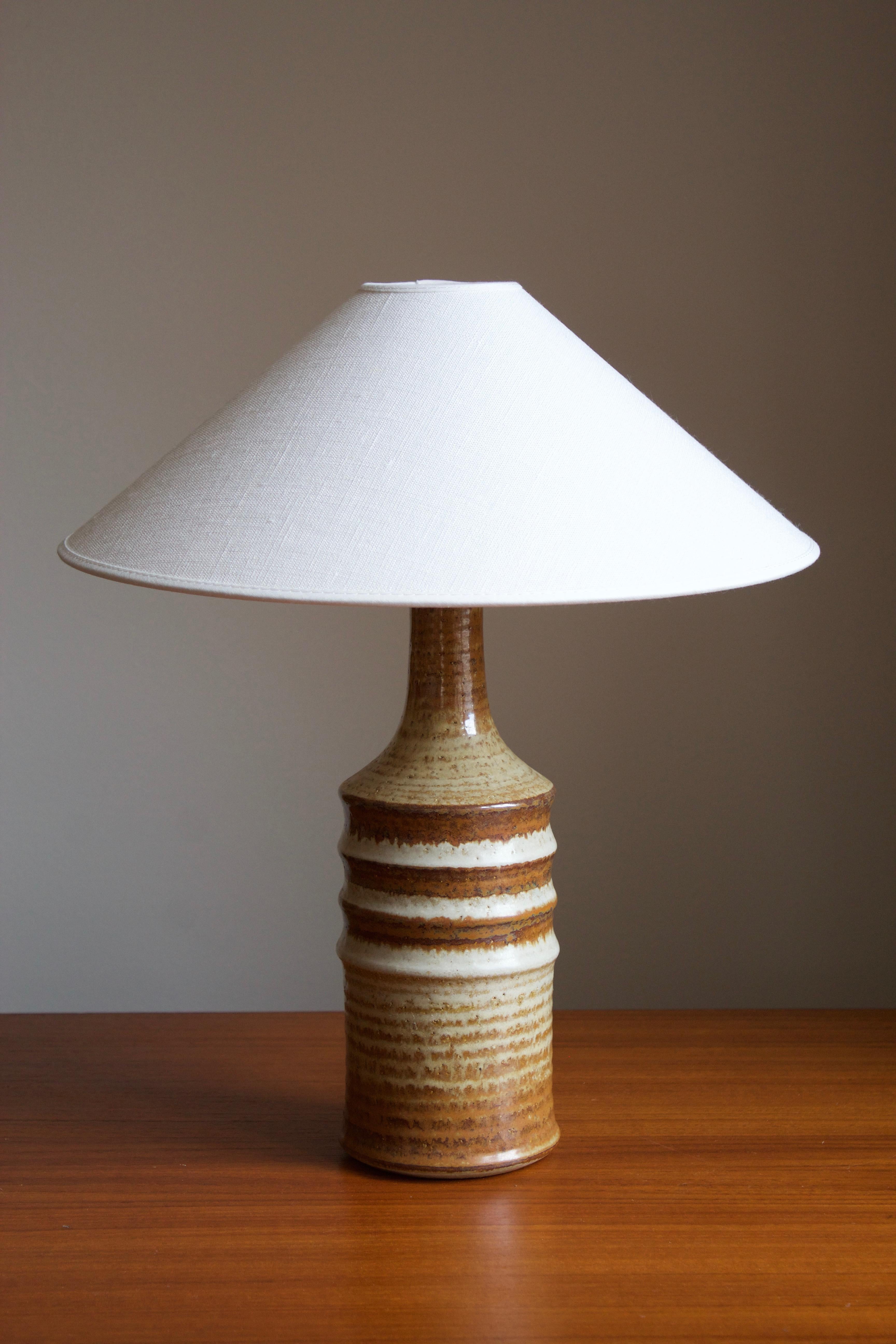 A table lamp produced by Søholm Keramik, located on the island of Bornholm in Denmark. Features a highly artistic glazed and incised decor.

Sold without lampshade. Stated dimensions exclude the lampshade.

Glaze features brown-beige colors.

Other