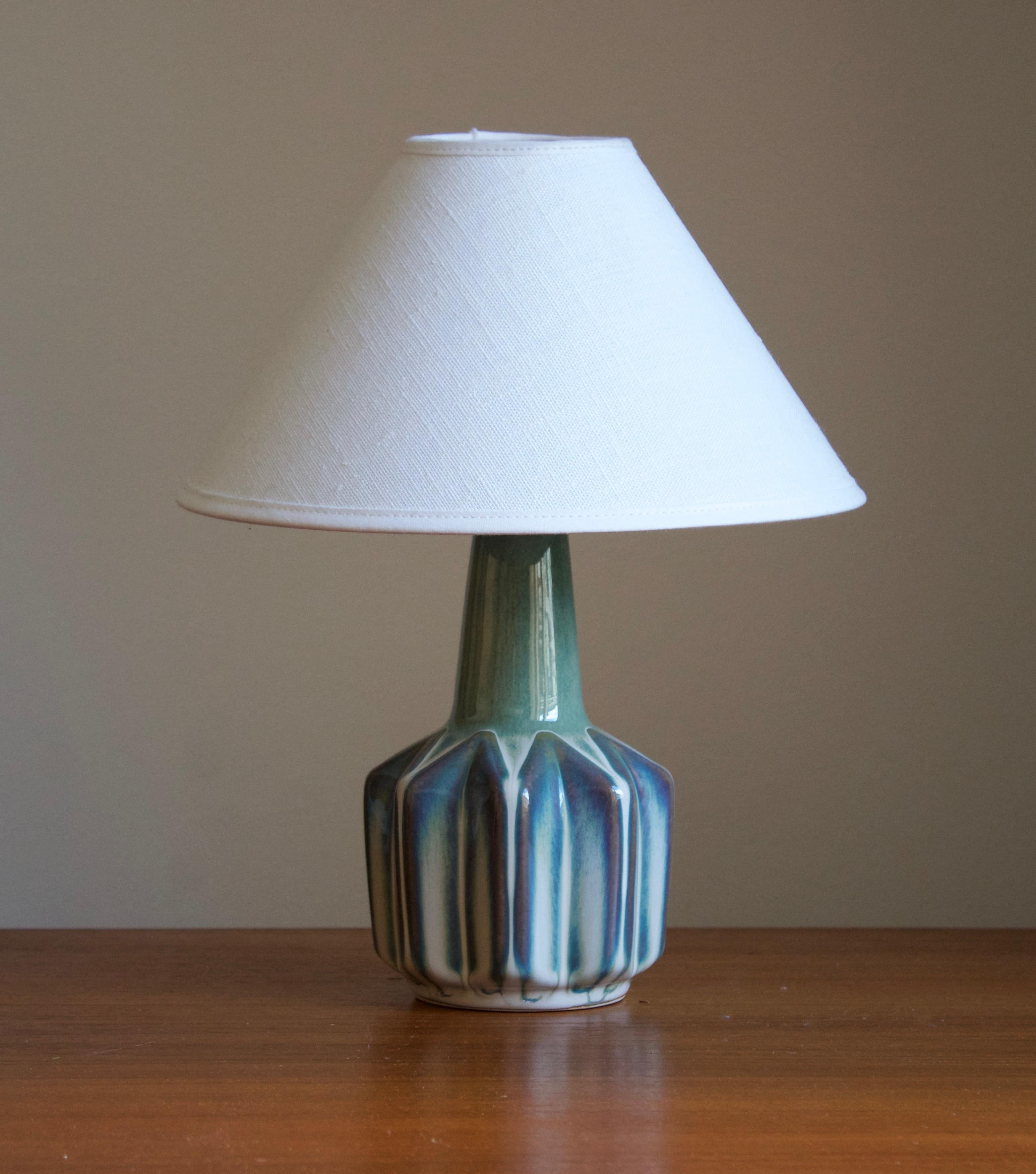 A table lamp produced by Søholm Keramik, located on the island of Bornholm in Denmark. Features a highly artistic glazed and incised decor.

Sold without lampshade. Stated dimensions exclude the lampshade.

Glaze features blue-green-white