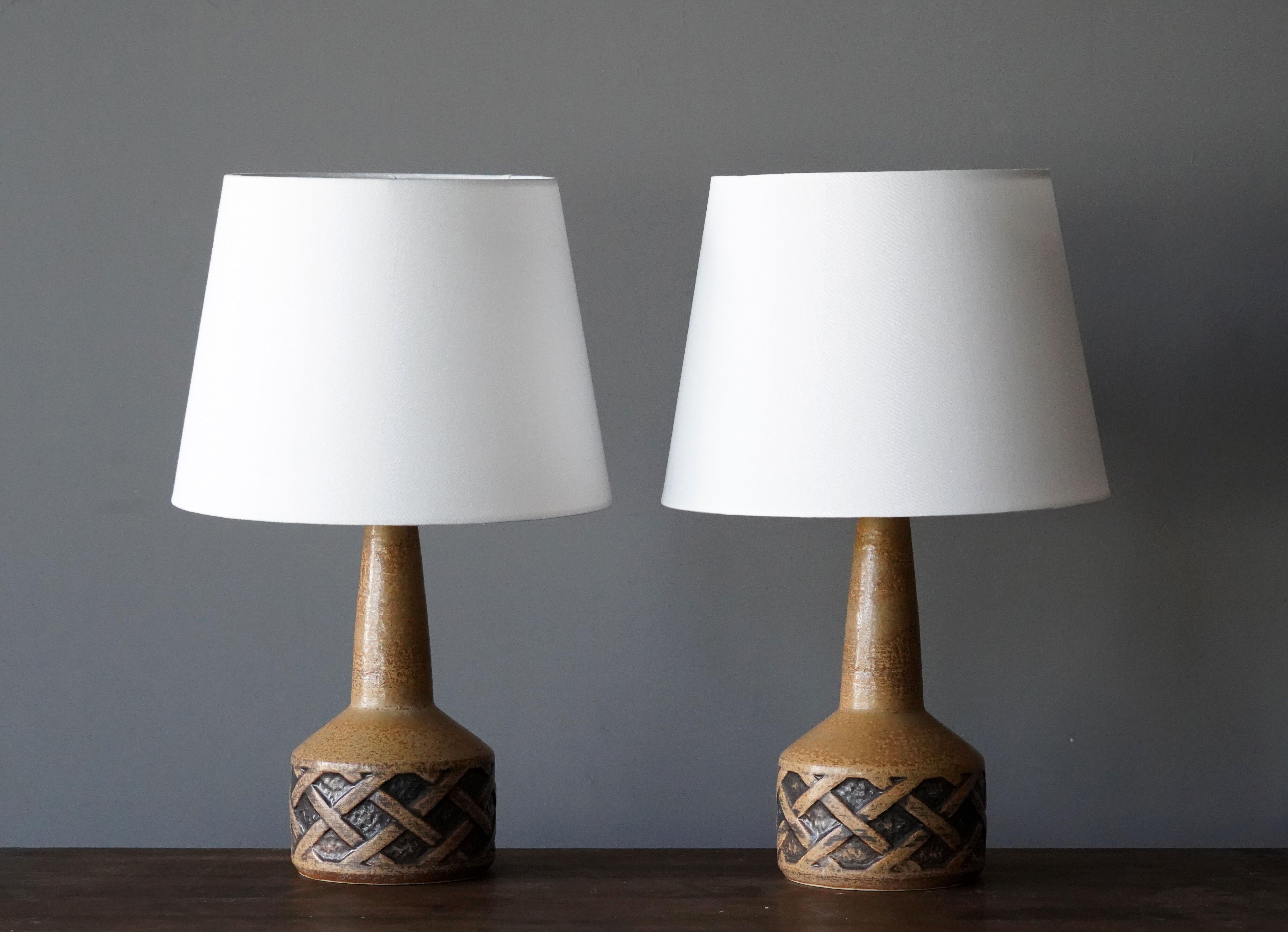 A pair of table lamps produced by Søholm Keramik, located on the island of Bornholm in Denmark. In a highly artistic brown / beige glaze. 

Lampshades are attached for reference and are not included in the purchase. Dimensions approximate,
