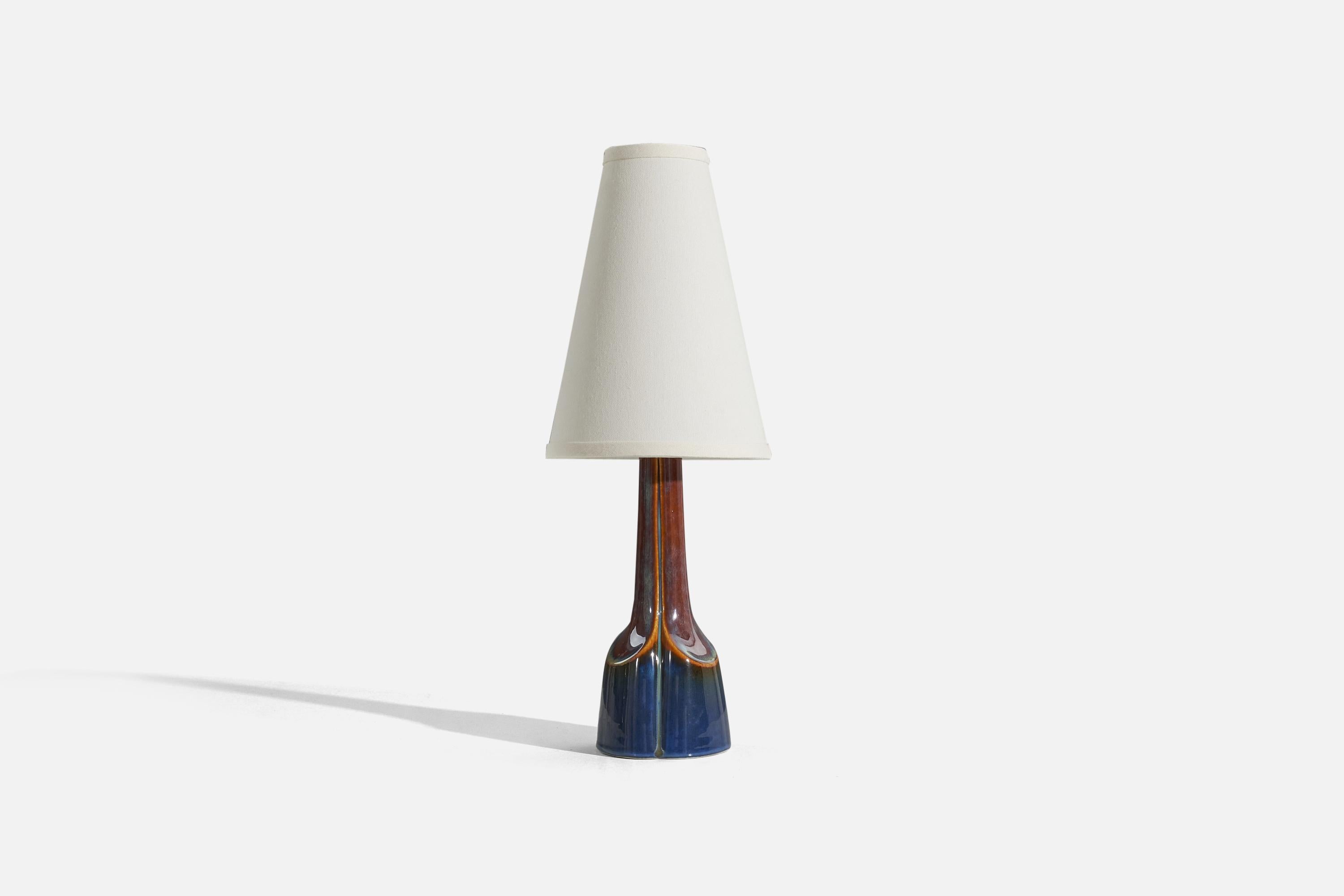 A blue and brown, glazed stoneware table lamp designed and produced by Søholm Stentøj, Denmark, c. 1960s.

Sold without lampshade. 
Dimensions of Lamp (inches) : 13.1875 x 4.25 x 4.25 (H x W x D)
Dimensions of Shade (inches) : 3.25 x 7.25 x 10