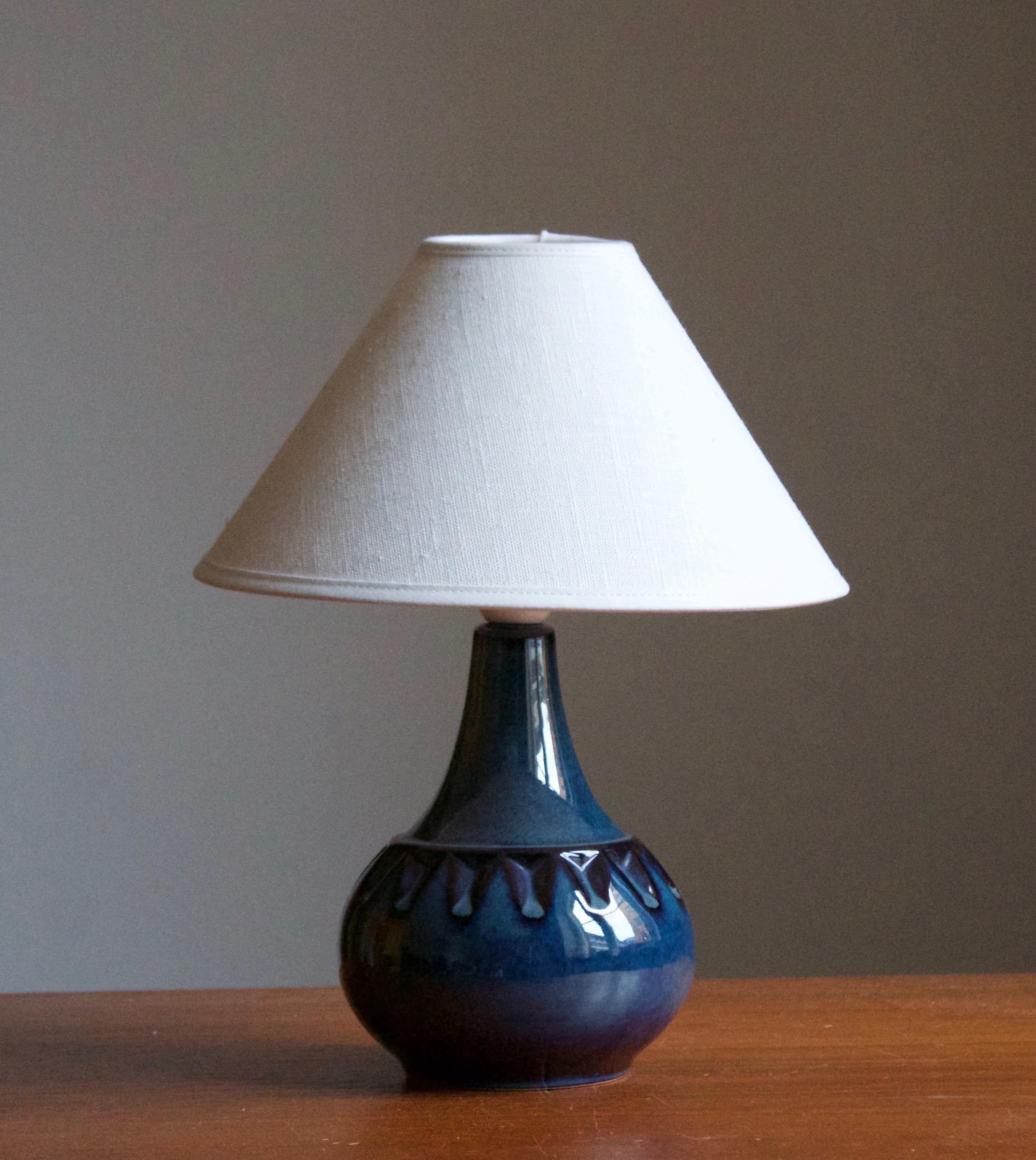 A table lamp produced by Søholm Keramik, located on the island of Bornholm in Denmark. Features a highly artistic glazed and incised decor. 

Sold without lampshade. Stated dimensions exclude the lampshade. Height includes socket.

Other