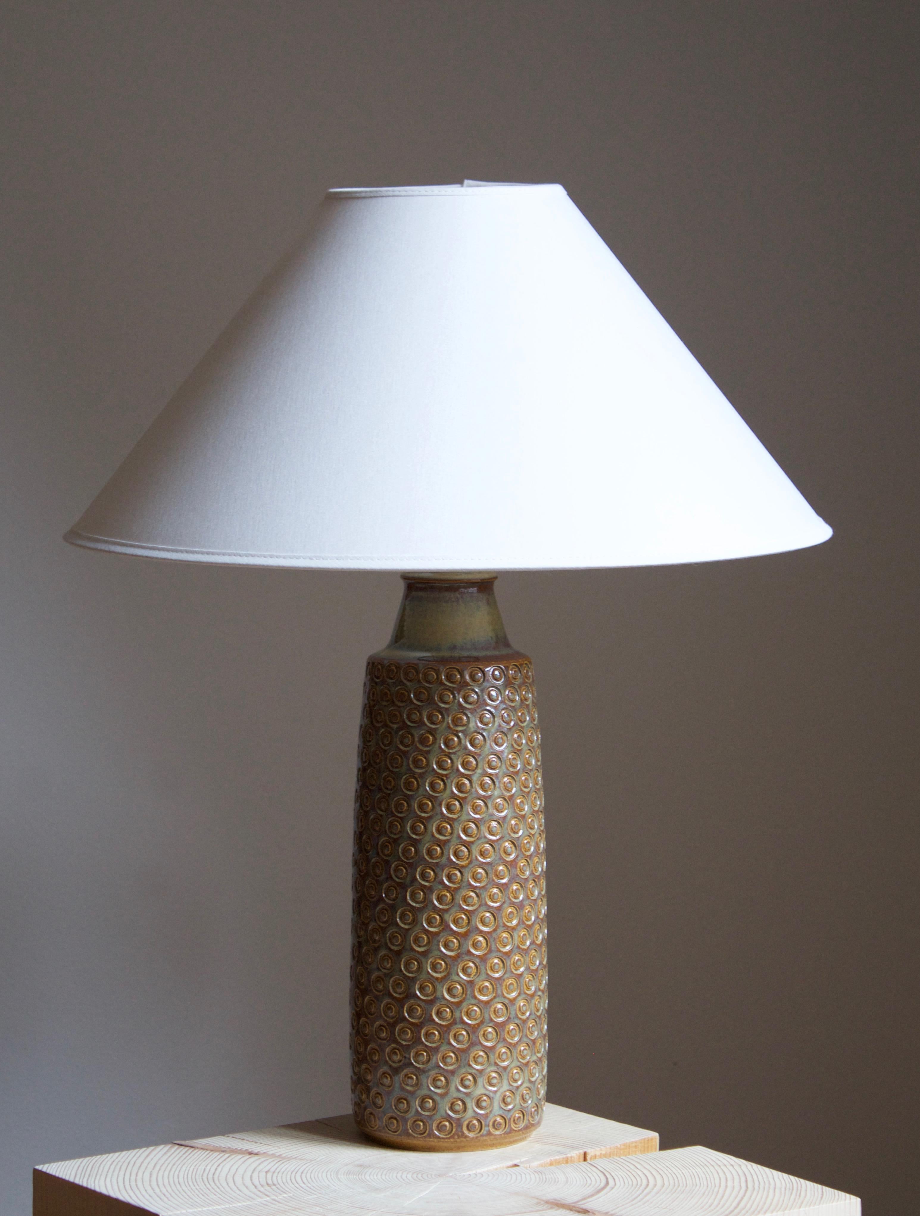 A large table lamp produced by Søholm Keramik, located on the island of Bornholm in Denmark. Features a highly artistic glazed and incised decor. 

Sold without lampshade. Stated dimensions exclude the lampshade.

Glaze features brown-green