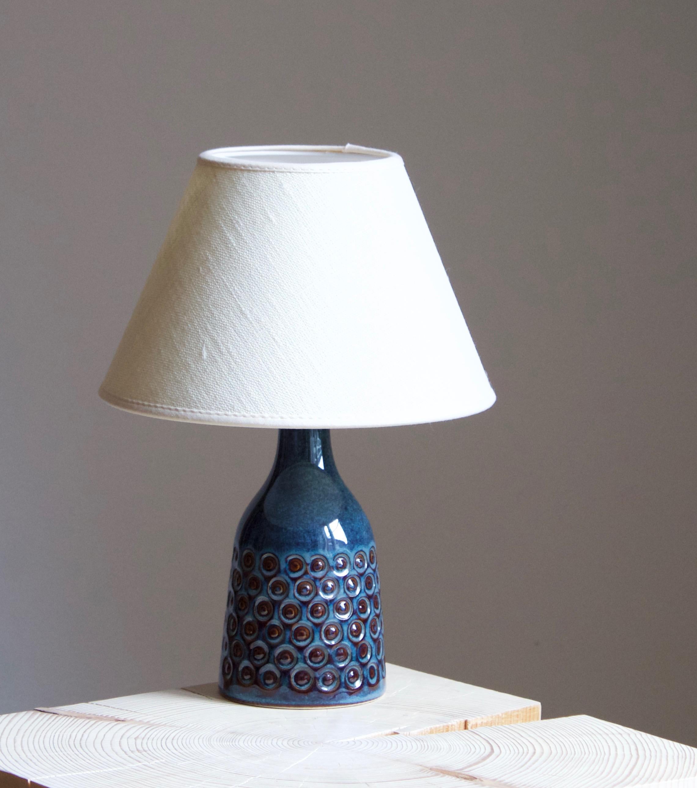 A table lamp produced by Søholm Keramik, located on the island of Bornholm in Denmark. Features a highly artistic glazed and incised decor. 

Sold without lampshade. Stated dimensions exclude the lampshade. Height includes socket.

Glaze features