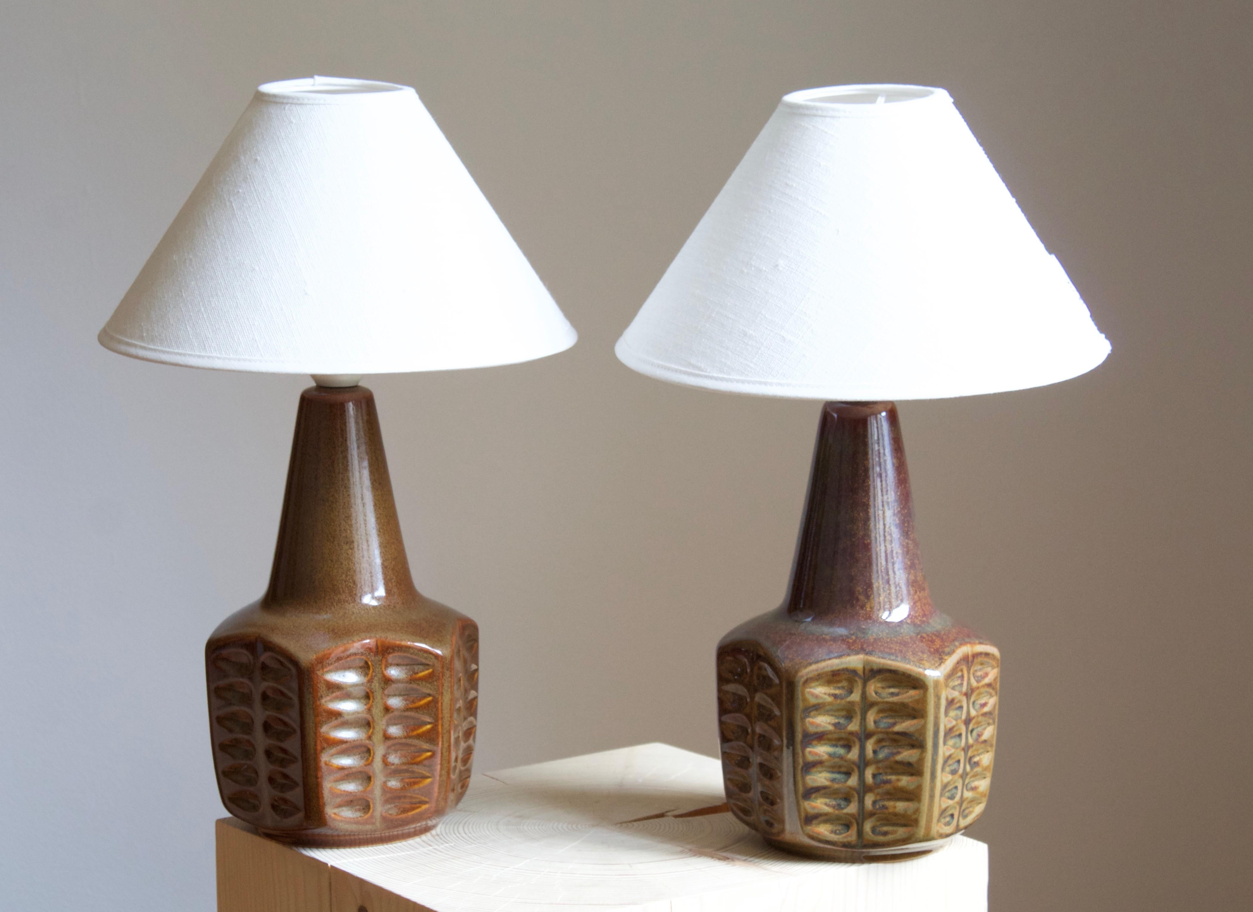A pair of table lamps produced by Søholm Keramik, located on the island of Bornholm in Denmark. Features a highly artistic glazed and incised decor. 

Sold without lampshade. Stated dimensions exclude the lampshade.

Glaze features green-brown