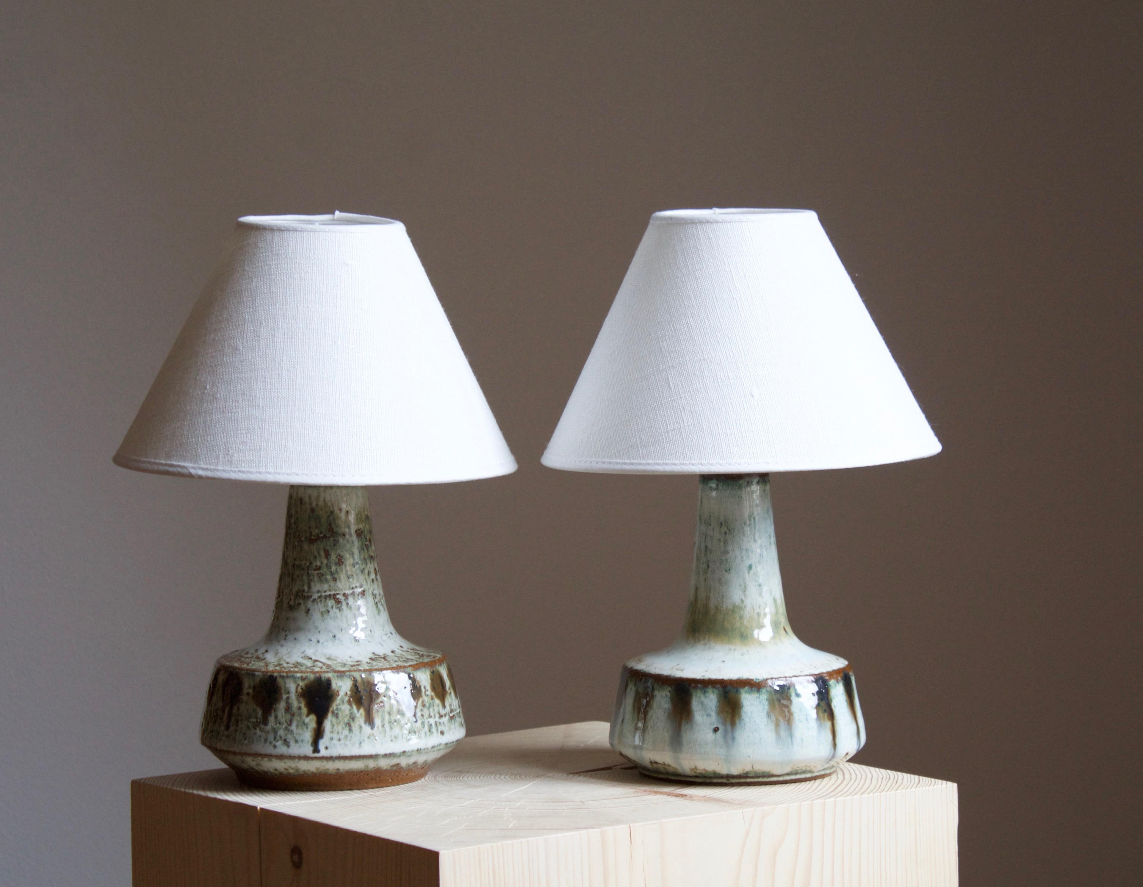 A pair of table lamps produced by Søholm Keramik, located on the island of Bornholm in Denmark. Features a highly artistic glazed and incised decor. 

Sold without lampshade. Stated dimensions exclude the lampshade. Height includes
