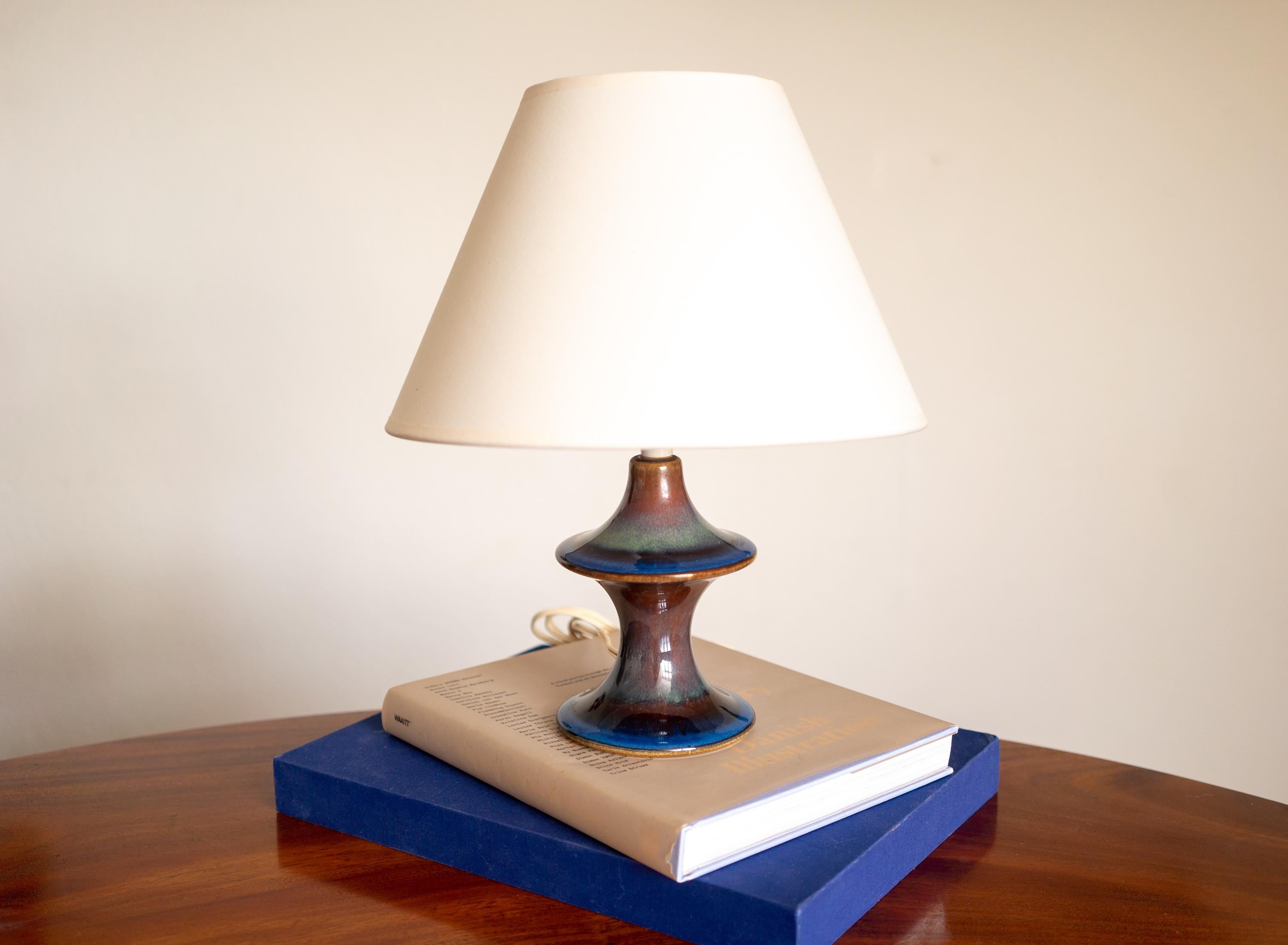 A blue-glazed stoneware table lamp designed and produced by Søholm,  Denmark, 1970s.

Sold without Lampshade. European plug.