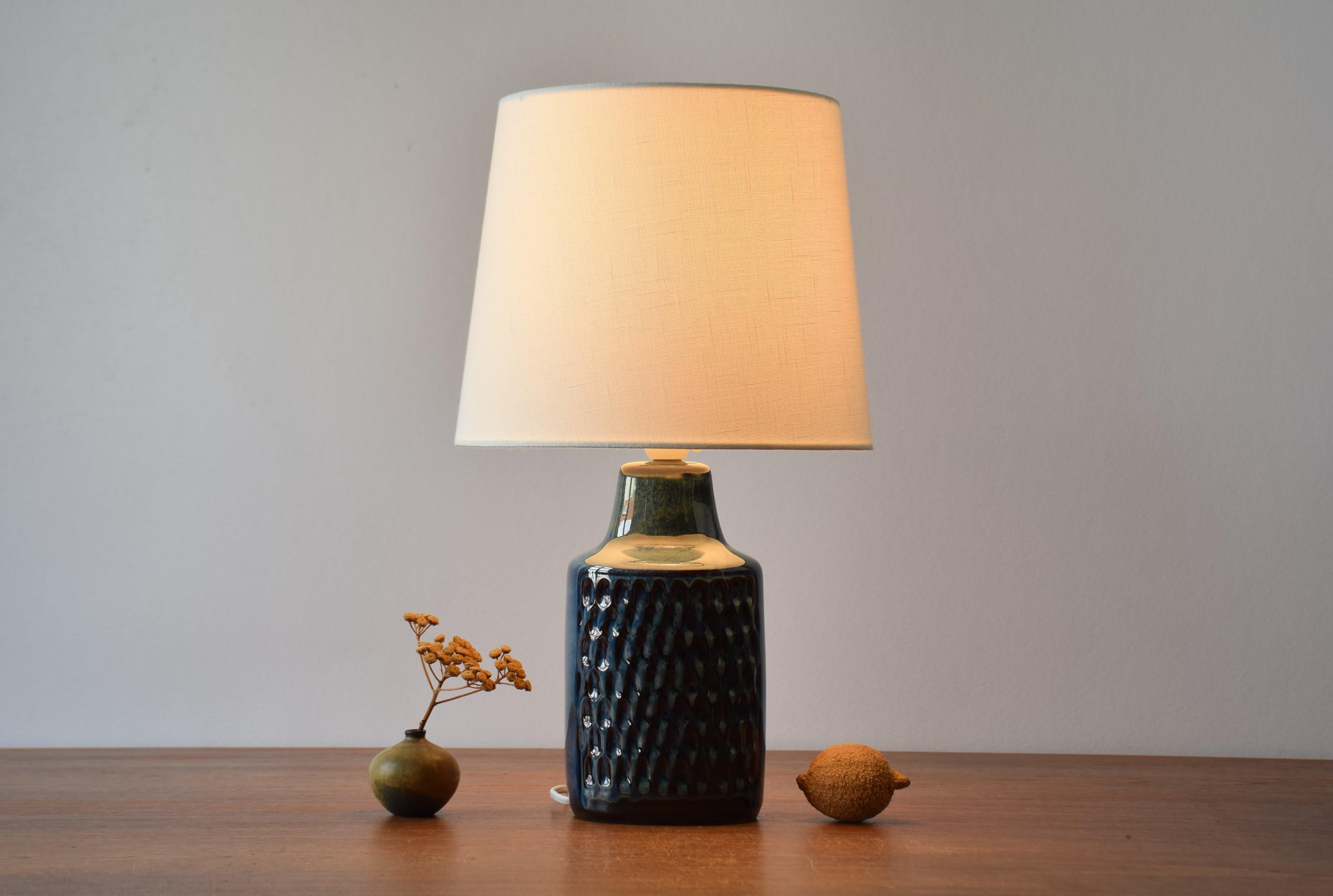 Mid-century Danish ceramic table lamp designed by Einar Johansen for Søholm Stentøj, Denmark. Made circa 1960s.

The lamp has a vivid glossy glaze in a dark blue with hints of brown and beige. 

Included is a new lamp shade designed and made in