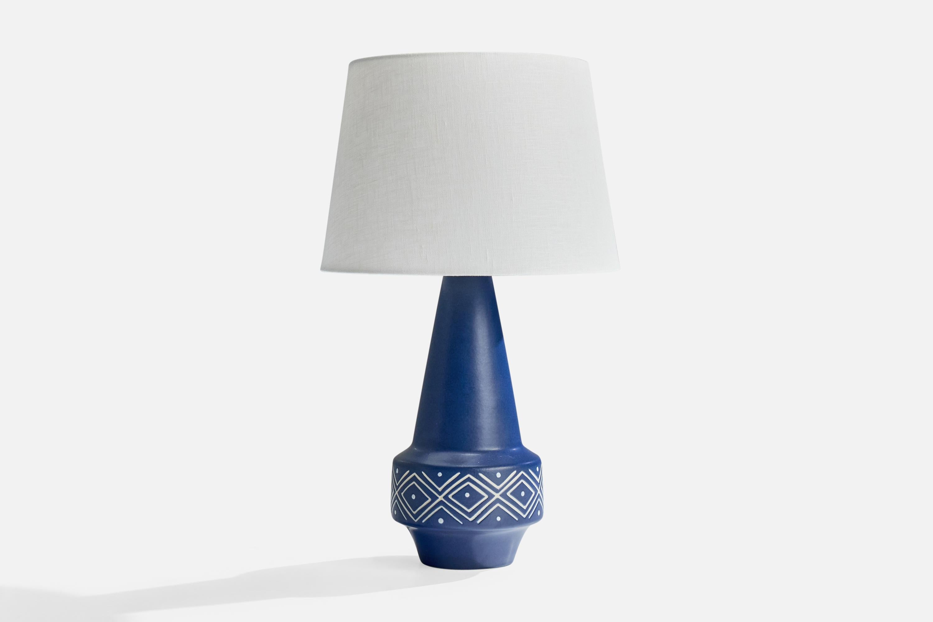 A blue-glazed table lamp produced by Søholm, Bornholm, Denmark, c. 1960s.

Dimensions of Shade (inches): 8” Top Diameter x 10” Bottom Diameter x 7” Height

Dimensions of Lamp with Shade (inches): 17” Height x 10” Diameter

Overall Dimensions