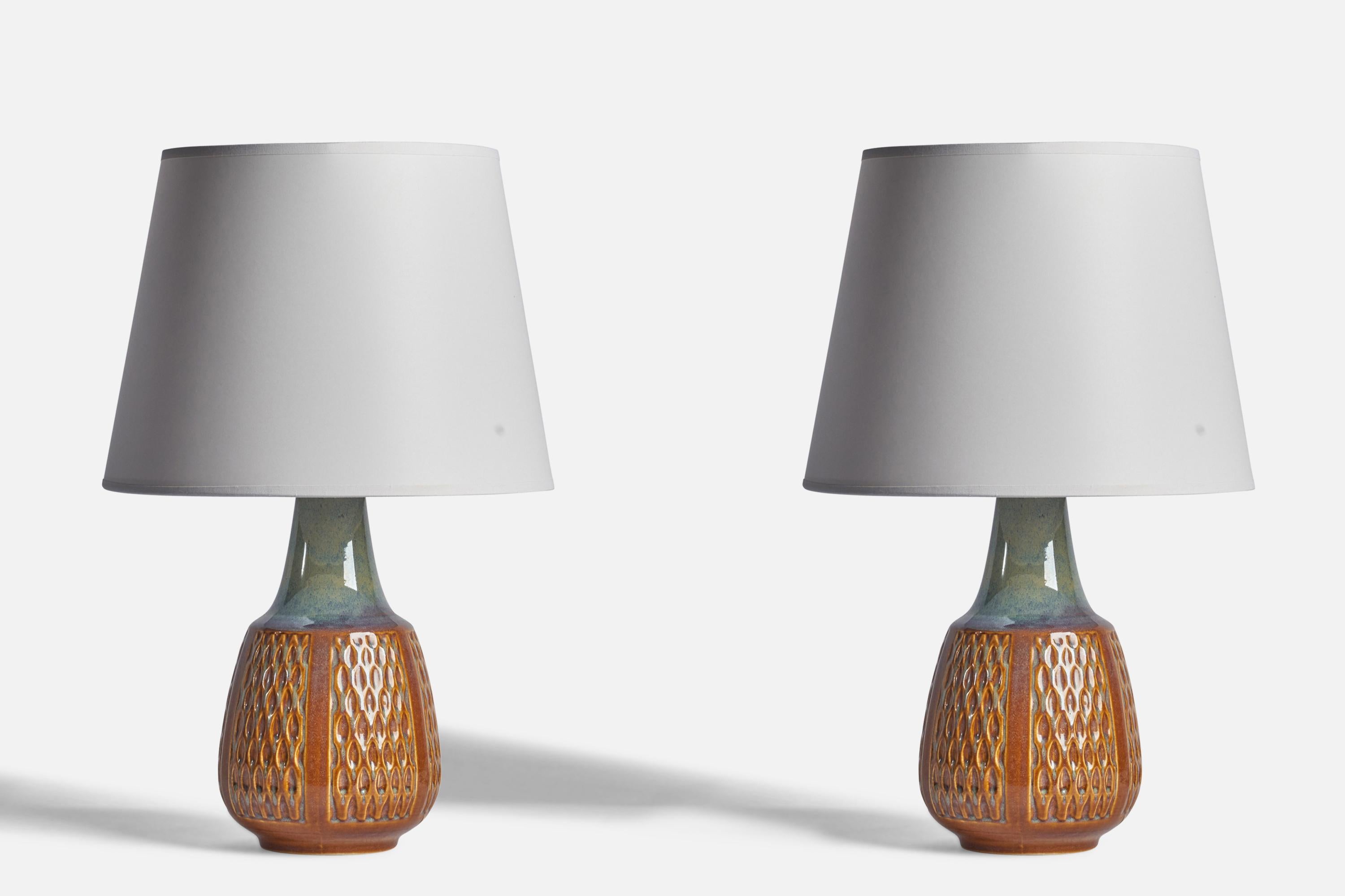 A pair of blue and brown-glazed stoneware table lamps designed and produced by Søholm, Bornholm, Denmark, c. 1960s.

Dimensions of Lamp (inches): 13.5” H x 6” Diameter
Dimensions of Shade (inches): 9” Top Diameter x 12” Bottom Diameter x 9”