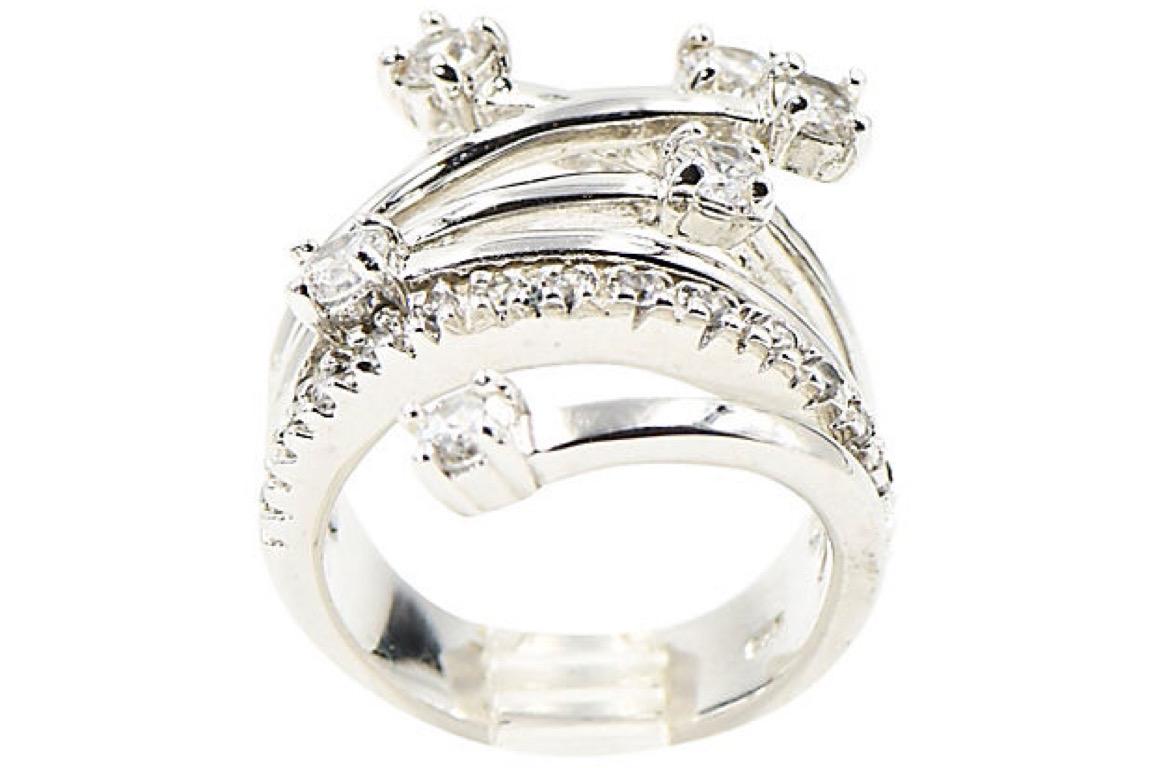 This ring is reminiscent of shooting stars or fireworks. The sterling silver ring has branches that crossover one another with prong set crystals at the end of each branch. There is also a singular band that just has crystals going across. The back