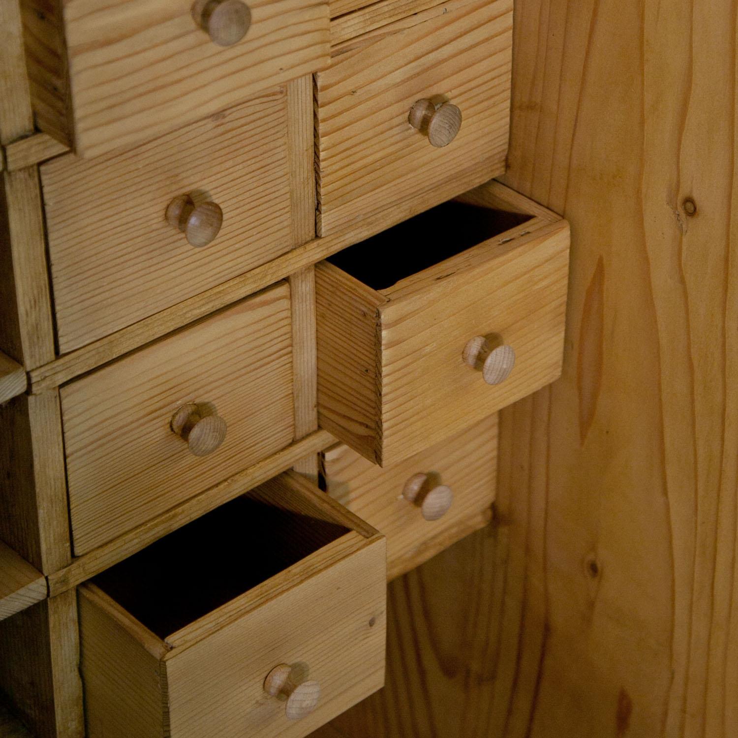 Small play shop for children out of softwood. The shop has display cases to the sides and several drawers and compartments.