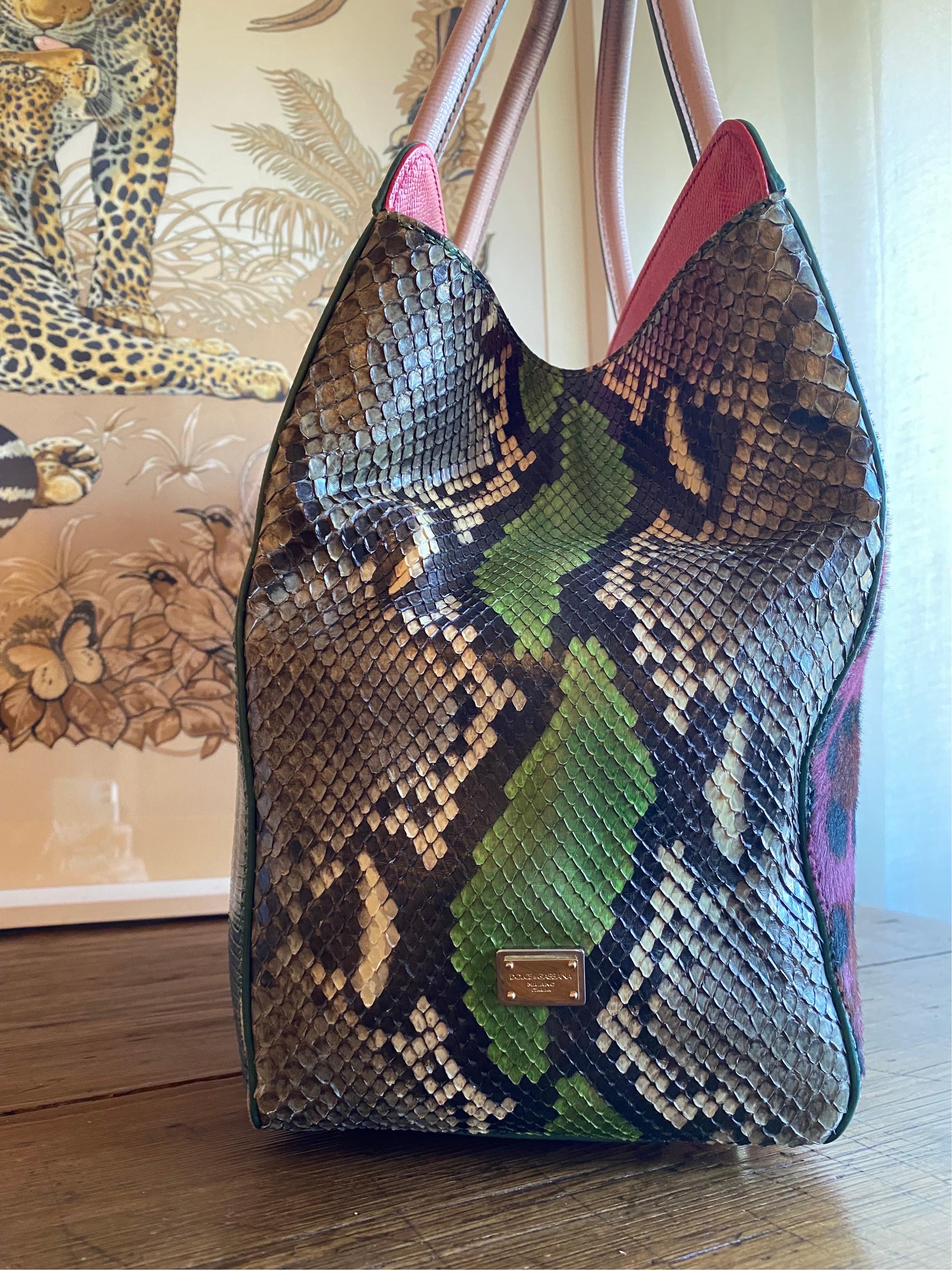 Particular Dolce & Gabbana bag to be worn on the shoulder or by hand. Made of pony skin in shades of dark pink on one side and with a blue reptile print on the other; the side portions are in colored python. The handles are in pink printed leather.