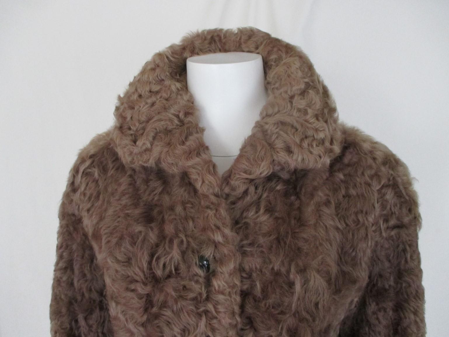 This vintage coat is made of curley lamb fur.

We offer more exclusive  fur items, view our frontstore.

Details:
Color: brown
Made in Germany
2 closing hooks, no pockets
Fully lined
The size fits as small, US 6-8/ EU 36-38, see section
