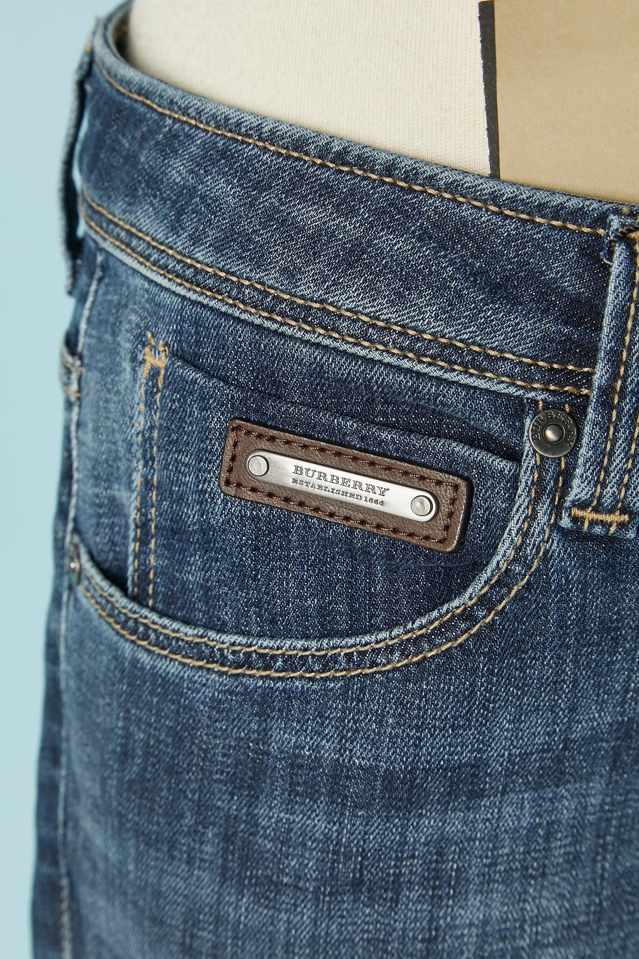 Jean court en denim avec passepoil à carreaux à l'intérieur. Composition du tissu : 98% coton, 2% élasthanne. 
Fermeture à bouton de marque, boutonnière et fermeture à glissière sur le milieu supérieur du devant. Clous de marque. Poche sur les deux