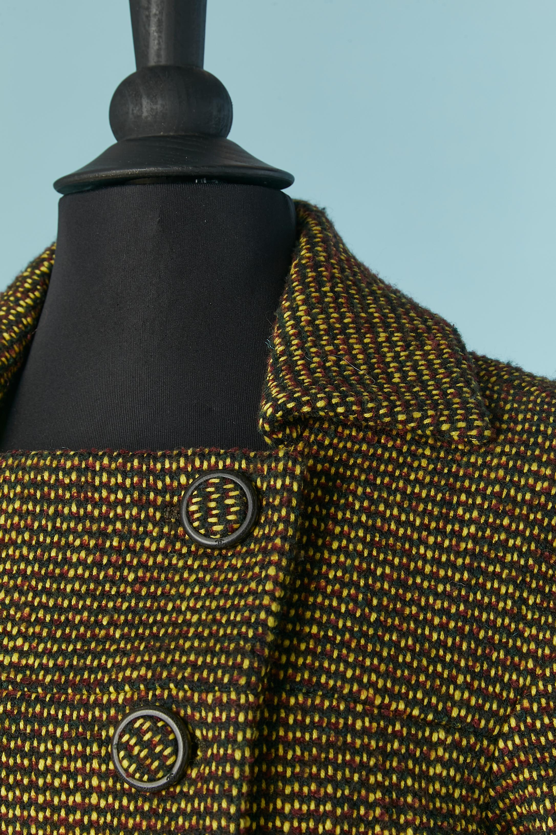 Chaqueta corta cruzada de Tweed. 
Composición del tejido principal: 40% algodón, 36% lana, 16% acrílico, 5% poliamida, 3% poliéster. 
Forro de seda con la marca. 
Botón de banda recubierto de la misma tela y madera en el centro delantero. 
TALLA 38