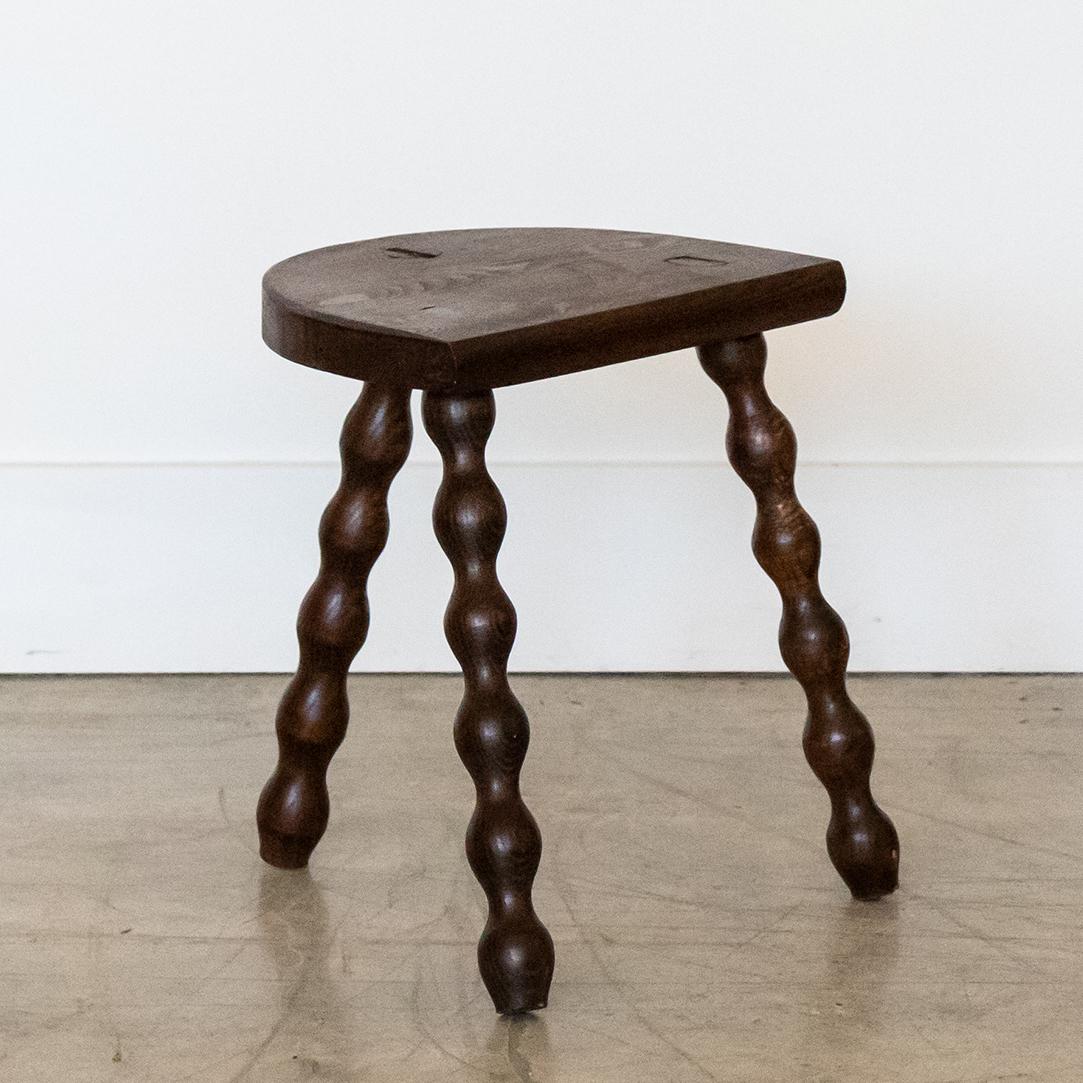 Vintage short wood stool with semi-circle seat and wavy tripod legs from France. Original wood finish with great age markings and patina. Can be used as a stool or as side table next to chairs.
 
  