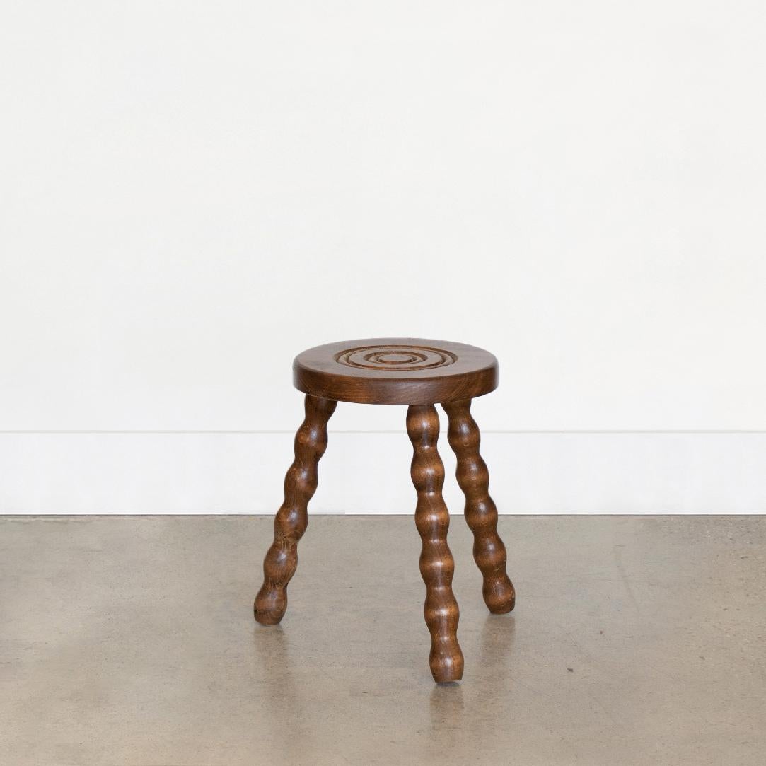 Vintage wood stool with beautiful wavy wood legs from France. Circular seat with unique carved ring detail on top. Original wood finish with great age markings and patina. Can be used as small stool or as side table next to chairs. 

