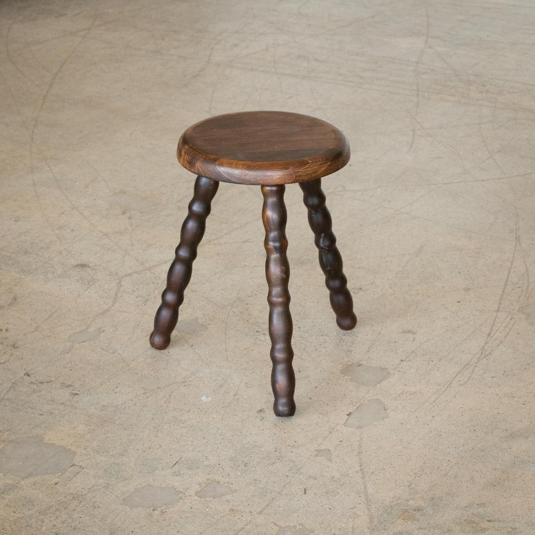 Vintage short wood tripod stool with circular seat and wavy legs from France. Original wood finish with great age markings and patina. Can be used as a stool or as side table next to chairs.


