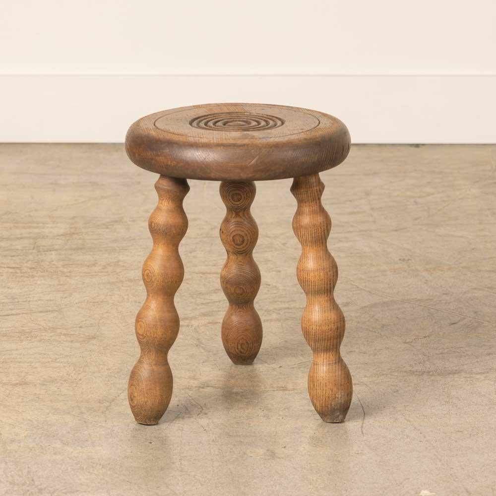 Sgabello vintage in legno con bellissime gambe ondulate e seduta circolare, proveniente dalla Francia. Finitura originale in legno con grandi segni dell'età e patina. Può essere utilizzato come sgabello o come tavolino accanto alle sedie. 