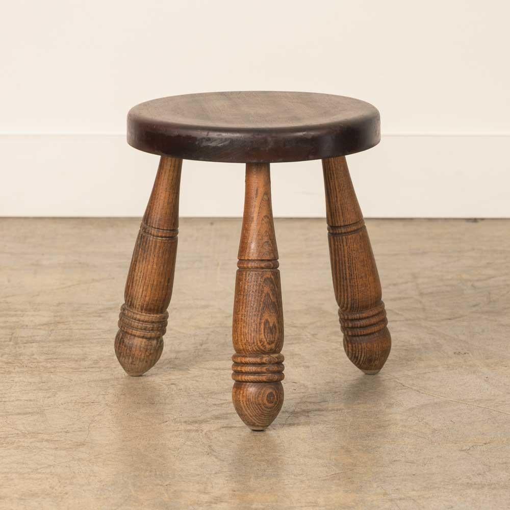 Sgabello corto in legno vintage con bellissime gambe in legno intagliato e seduta circolare, proveniente dalla Francia. Finitura originale in legno con grandi segni dell'età e patina. Può essere utilizzato come sgabello o come tavolino accanto alle