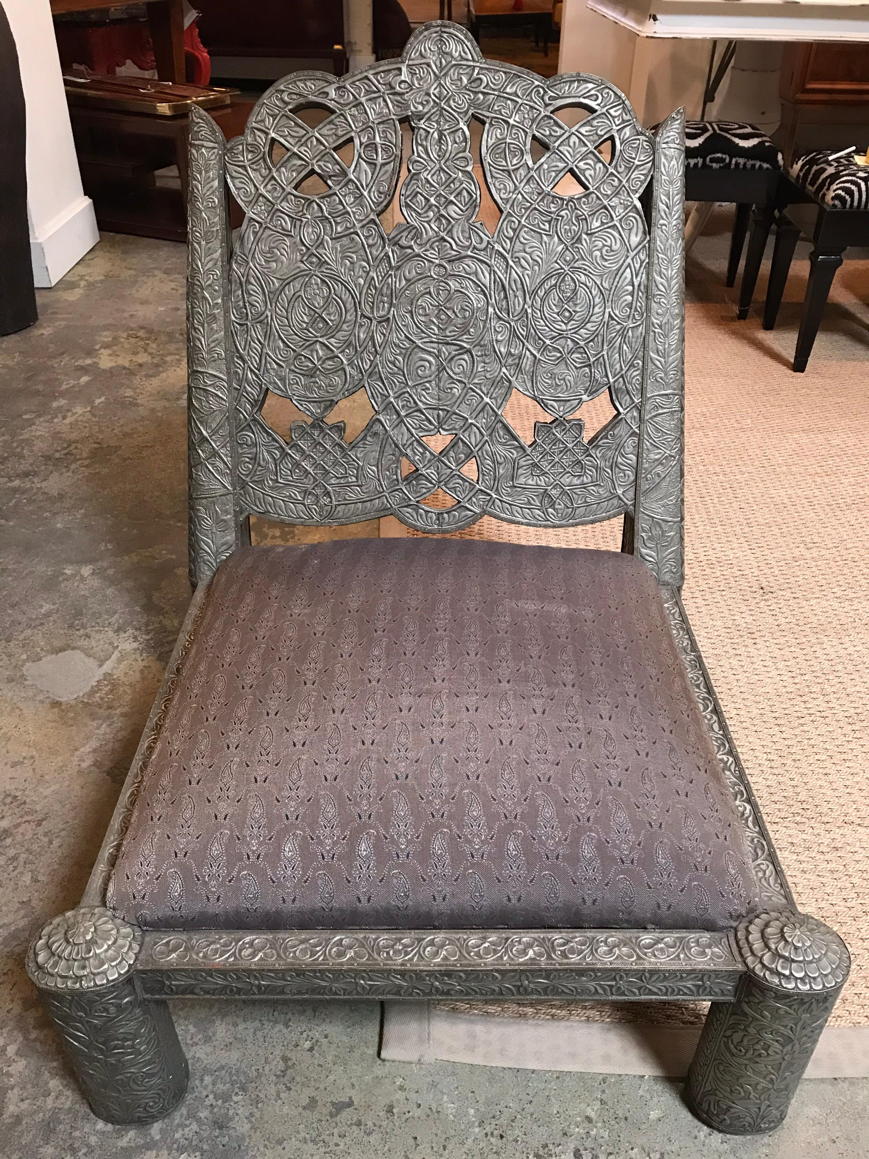 Cette chaise maharaja repousse est recouverte d'une fine couche de métal travaillé à la main qui est fixée à la chaise avec des moyens traditionnels. La hauteur du siège est d'un peu moins de 13 pouces.