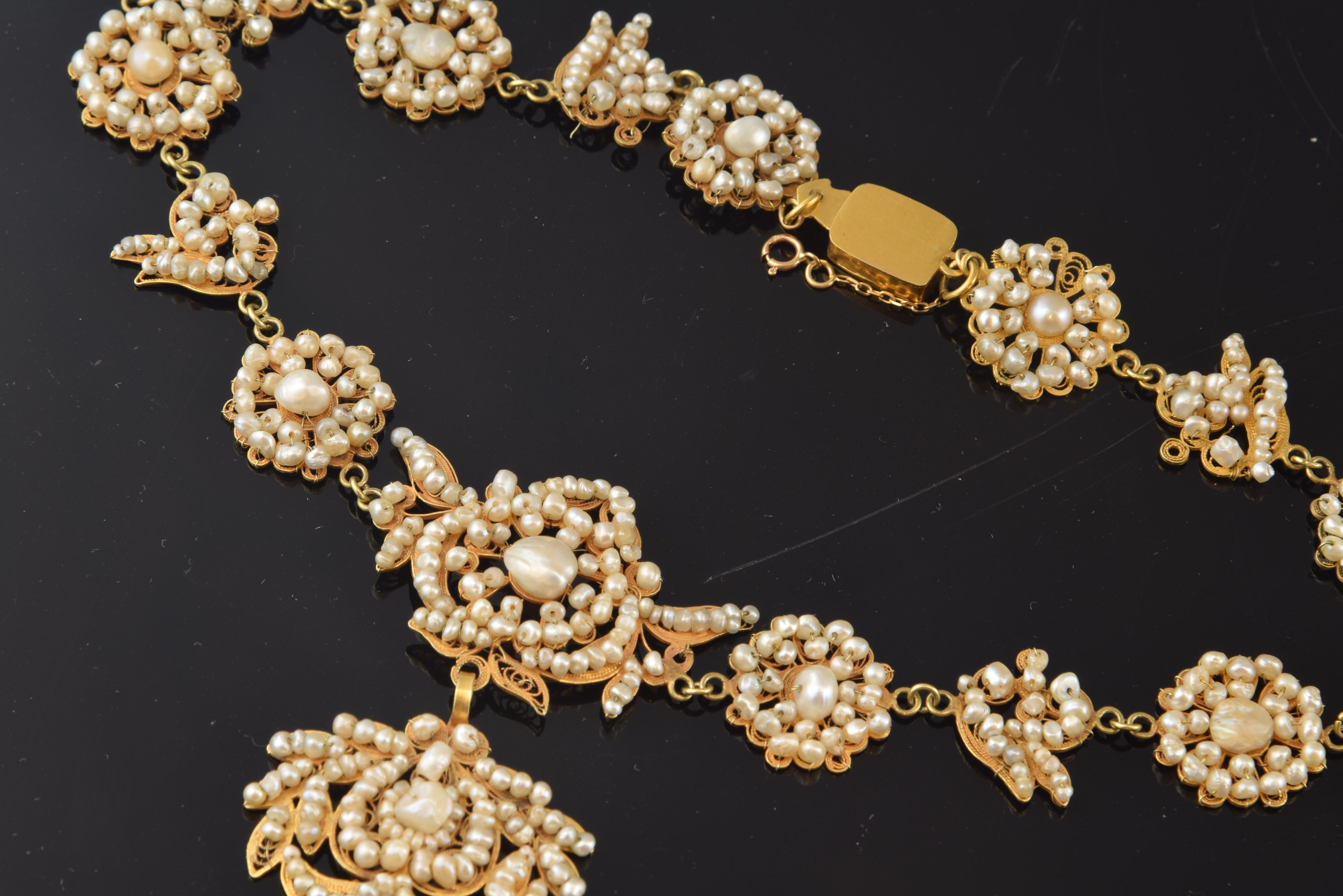 Popular style choker. Spain, circa late 19th century.
Gold choker and small pearls (of different shapes and sizes) with a rectangular closure secured with a chain and another ring clasp, which has a series of 