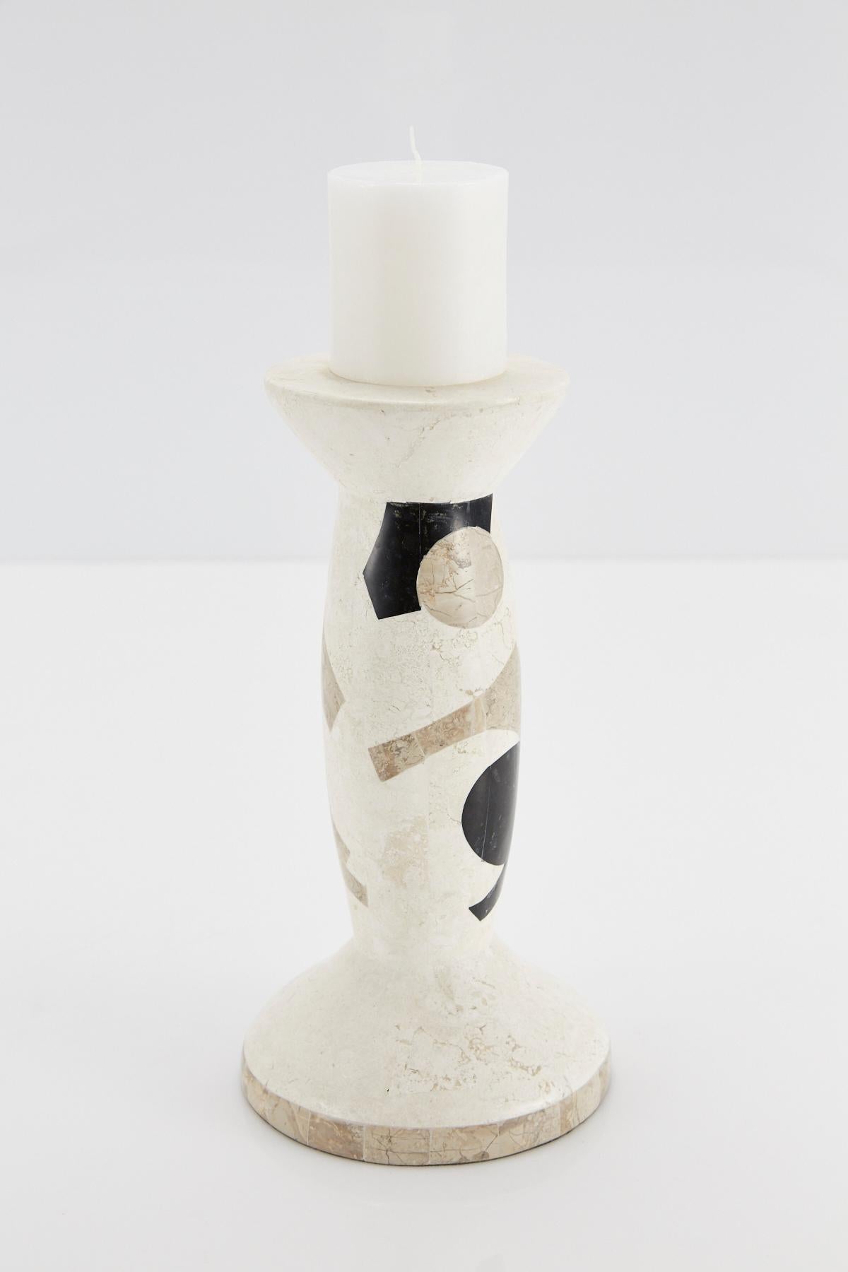 Short pillar candle holder. Body is comprised of fiberglass with exterior completely covered in black, white and beige tessellated stone in a fun Postmodern pattern. 

Coordinating medium and tall candlesticks also available.

All furnishings are