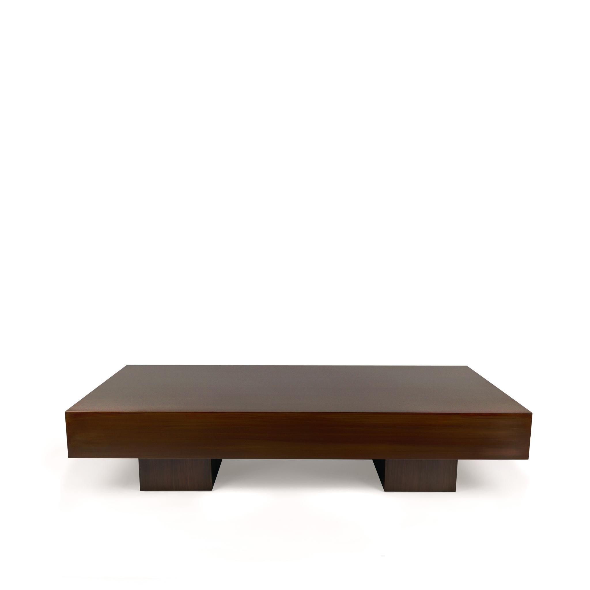 Der Hiro-Tisch ist ein einfaches architektonisches Objekt, das jedoch eine große Präsenz hat. Er ist robust und solide und hat eine auffallend schlichte Form. Handgefertigt mit einer warmen Vintage-Bronze-Behandlung, die das minimalistische Design