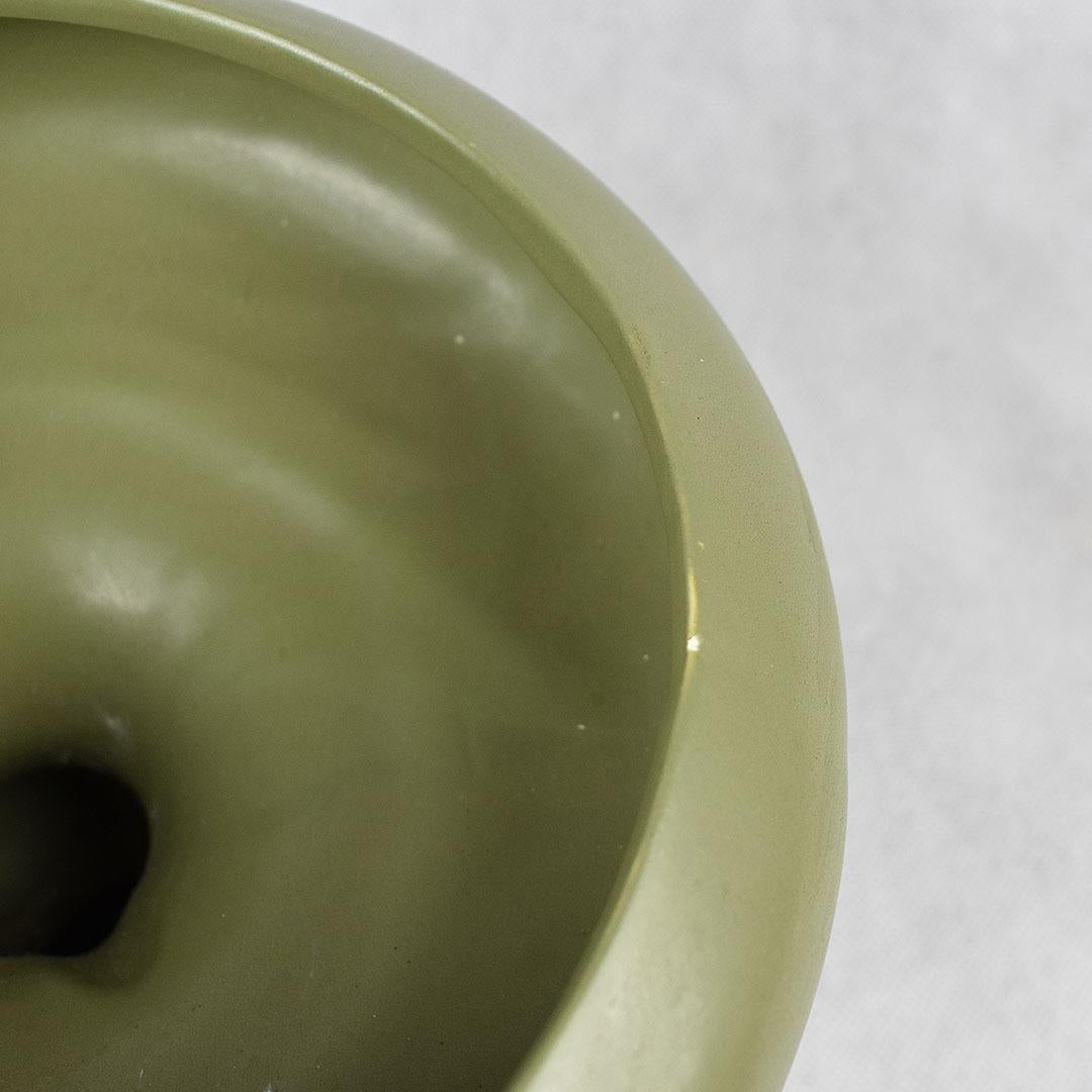 Short round green planter by McCoy for their Floraline line. A wide circular body sits upon a smaller green base. All glazed in a matte green hue. Although not stamped with the McCoy maker's mark on the bottom, Floraline was made by the famous