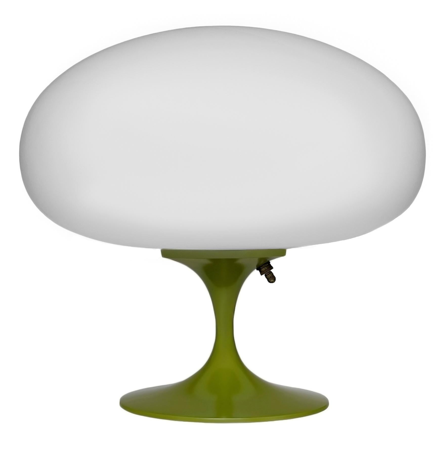 DIESER ARTIKEL IST VERSANDKOSTENFREI!

Eine elegante Stemlite-Tischleuchte von Design Line. Sie verfügt über einen Aluminiumguss-Sockel in einer skulpturalen Tulpenform. Der Lampenfuß ist in einem Retro-Avocadogrün gehalten. Der Lampenschirm aus