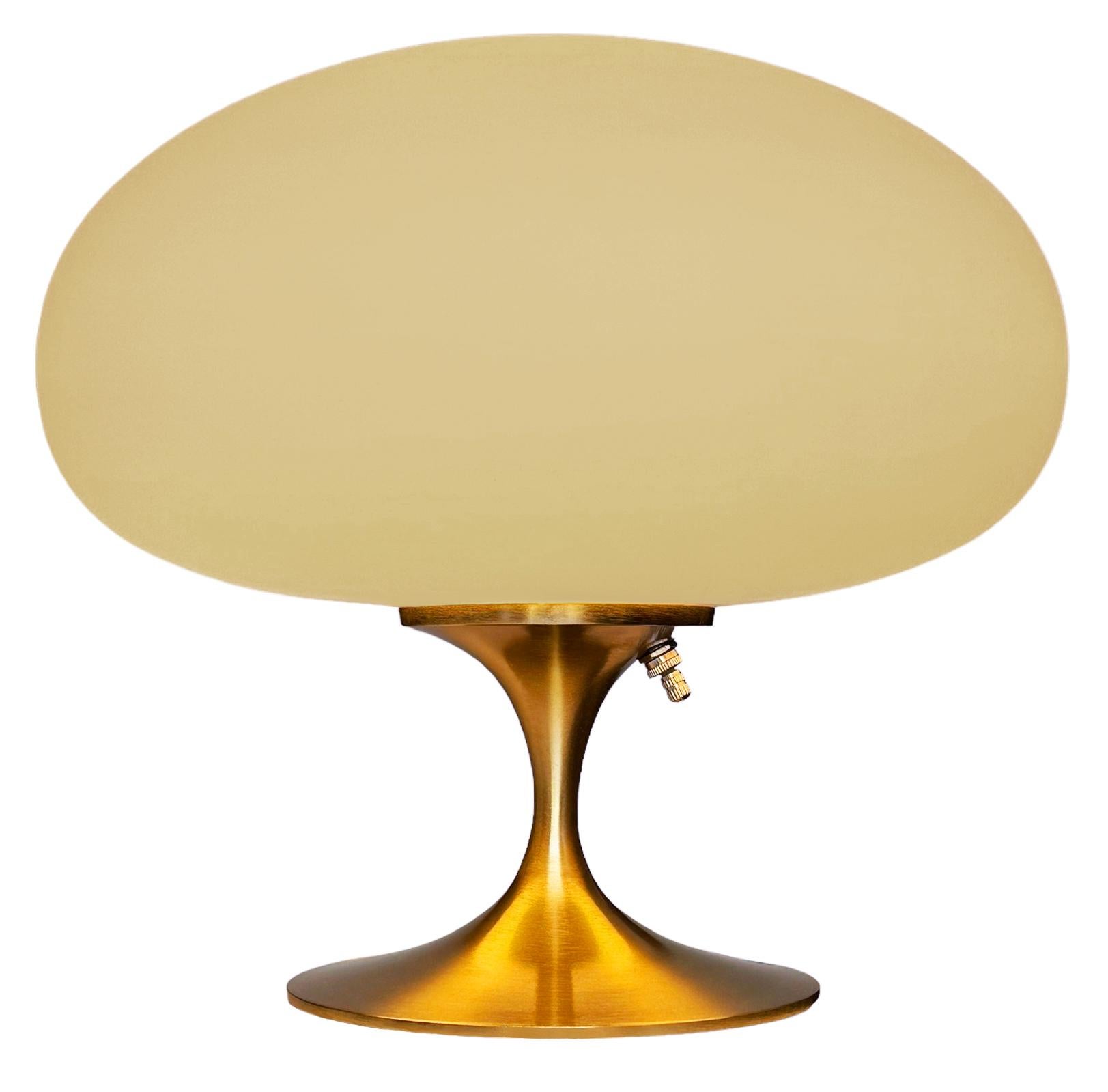 THIS ITEM IS ELIGIBLE FOR FREE SHIPPING!

A sleek stemlite table lamp made by Design Line. It features a cast aluminum main base in a sculptural tulip form. The lamp base is finished in beautiful rich brushed brass. The frosted glass lamp shade is