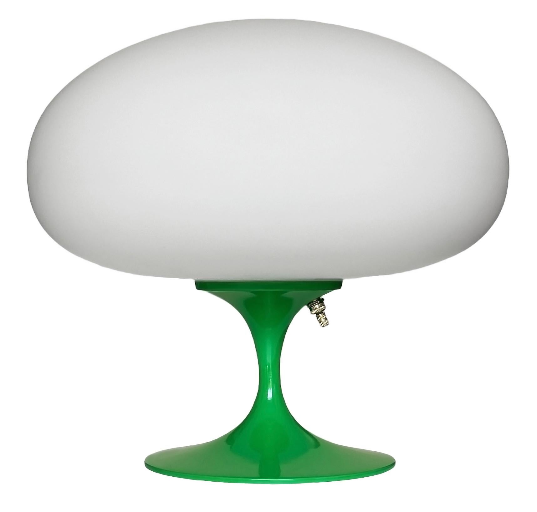 THIS ITEM IS ELIGIBLE FOR FREE SHIPPING!

A sleek stemlite table lamp made by Design Line. It features a cast aluminum main base in a sculptural tulip form. The lamp base is finished in a classic retro green. The frosted glass lamp shade is hand