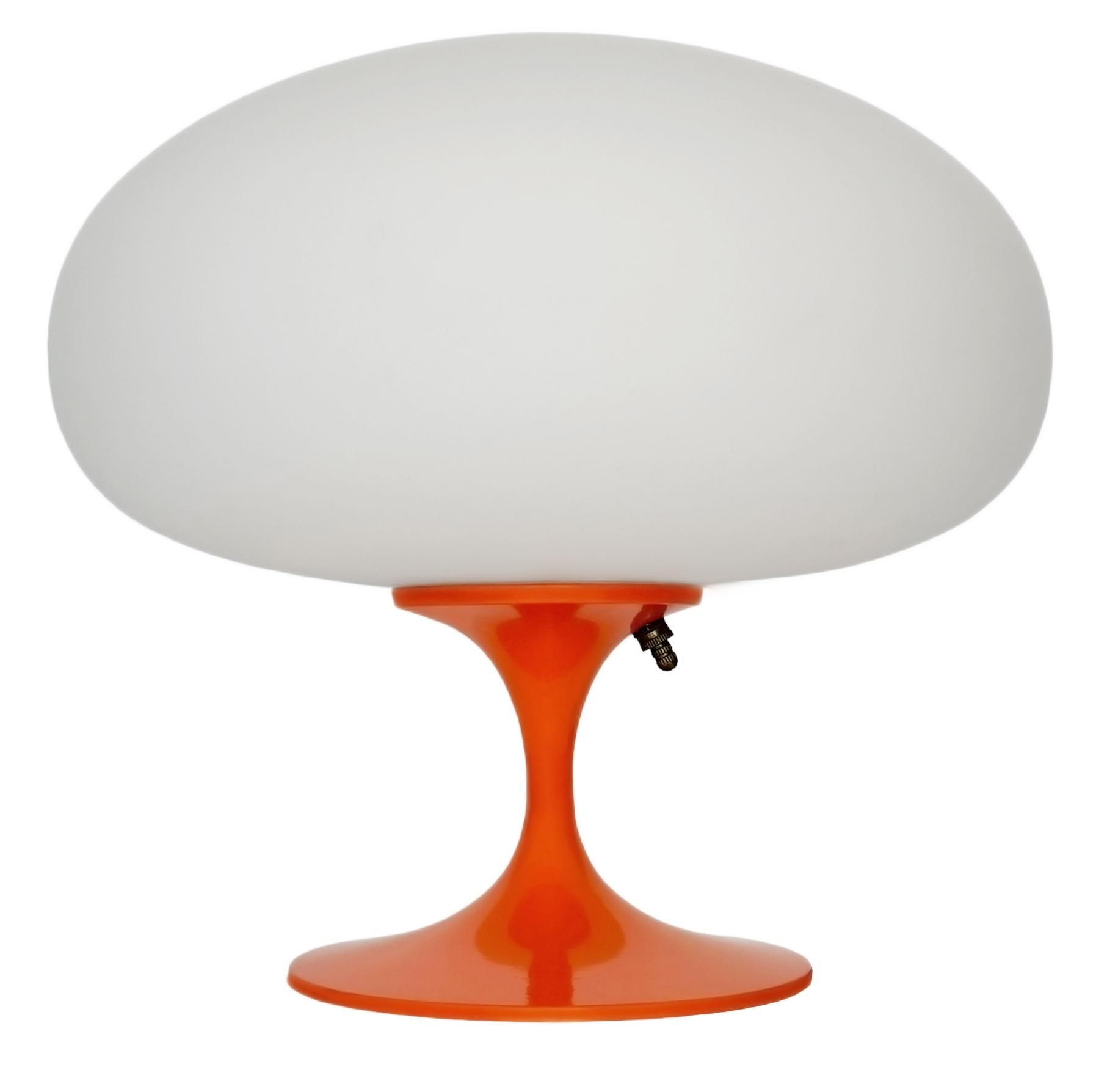 THIS ITEM IS ELIGIBLE FOR FREE SHIPPING!

A sleek stemlite table lamp made by Design Line. It features a cast aluminum main base in a sculptural tulip form. The lamp base is finished in a classic retro orange color. The frosted glass lamp shade is