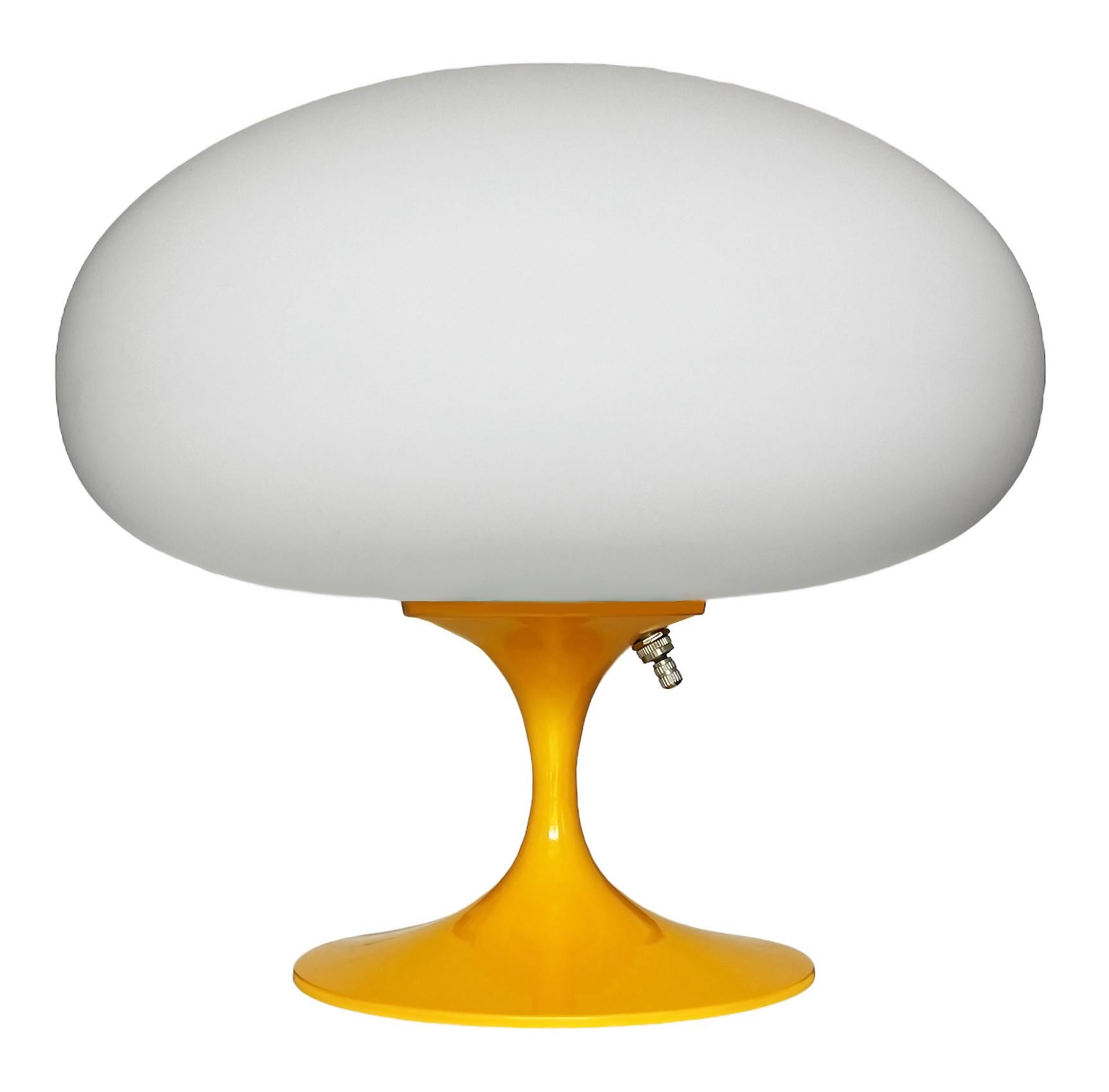 THIS ITEM IS ELIGIBLE FOR FREE SHIPPING!

A sleek stemlite table lamp made by Design Line. It features a cast aluminum main base in a sculptural tulip form. The lamp base is finished in high gloss light orange. The frosted glass lamp shade is hand