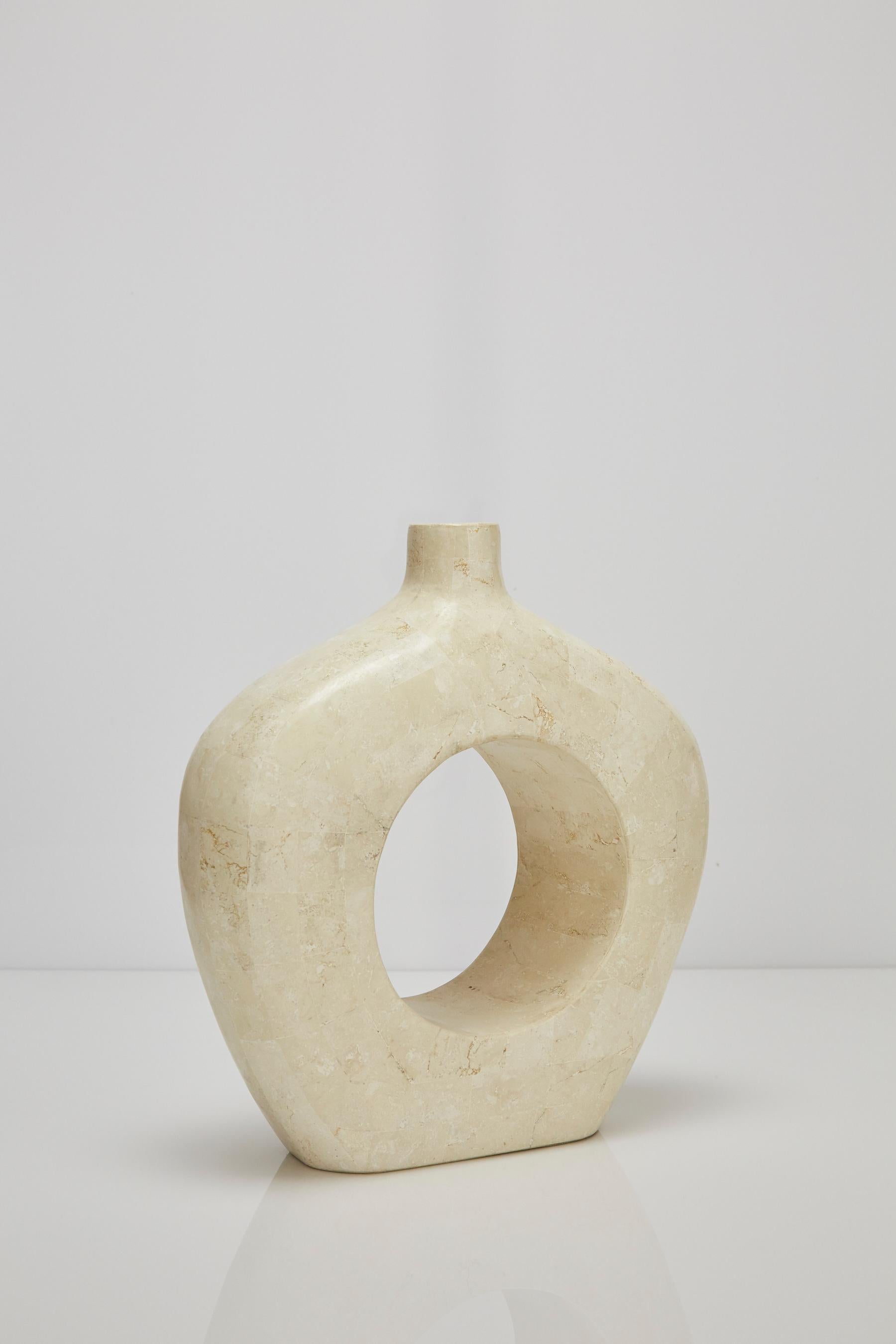 Shorter vase with O-shaped centre void. Executed in white ivory tessellated stone over a fiberglass body.

All furnishings are made from 100% natural Fossil Stone or Seashell inlay, carefully hand cut and crafted piece-by-piece and precisely inlaid