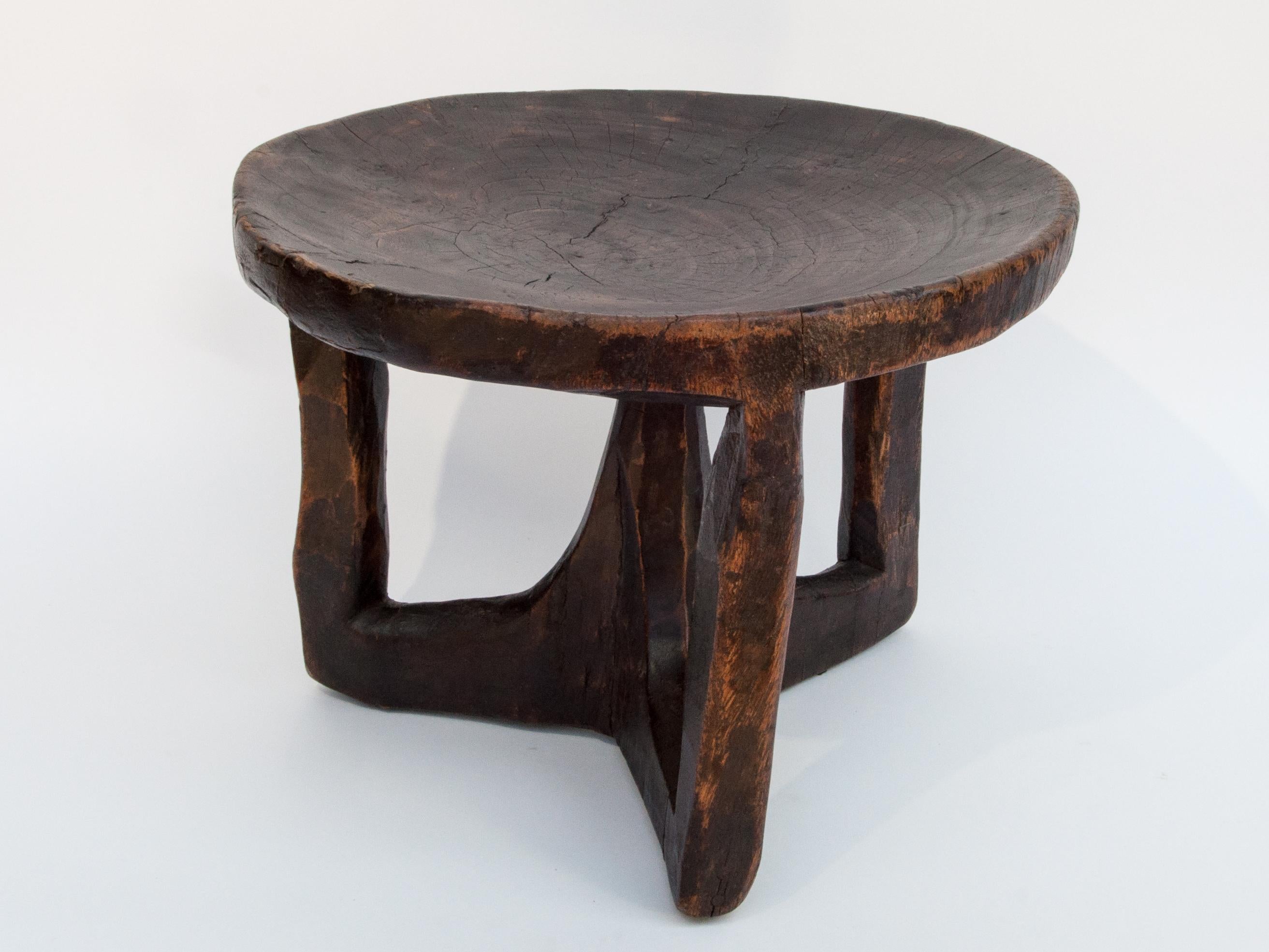 Short tribal wooden stool, from Ethiopia, mid-late 20th century.
Offered by Bruce Hughes.
This rustic wooden stool was fashioned by hand from a single piece of wood using basic tools. The adze marks are particularly visible on the underside of the