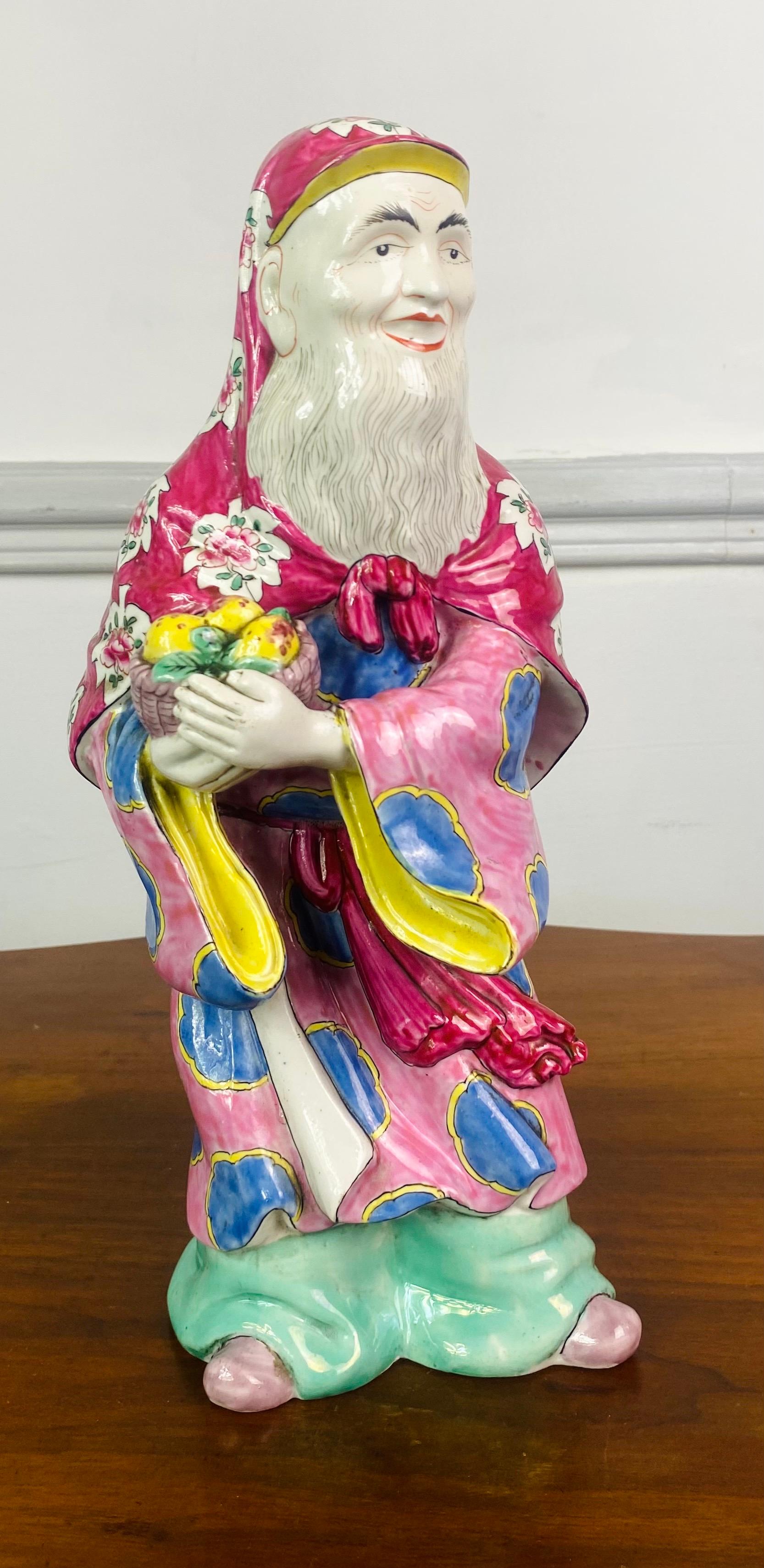 Very beautiful enameled porcelain statuette of the God Shou Lao, also called the old man of the South Pole. He is a Chinese Taoist god, Incarnation of the Antarctic stars, he is the god of wealth and longevity. He is shown here with a basket of