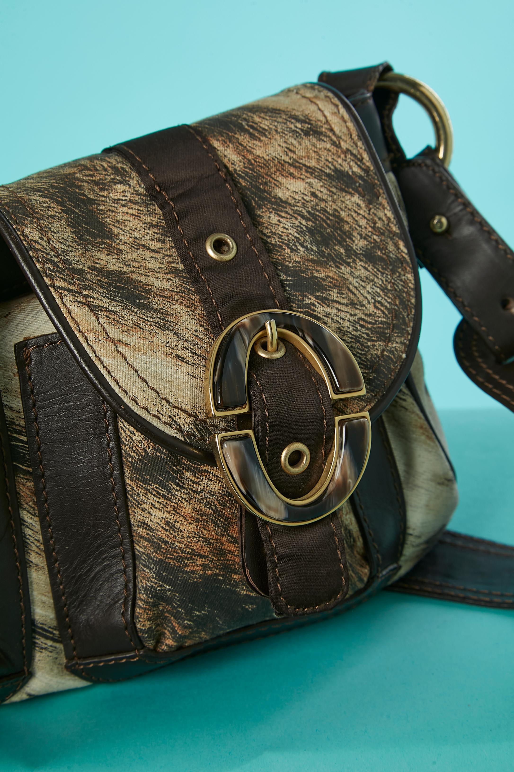 Shoulder bag in printed cotton and brown leather with 2 front pockets covered with flap with buckle and snap closure. One inside pocket with zip closure. Authenticity Hologram inside. Branded rayon and acetate lining. Adjustable shoulder strap.