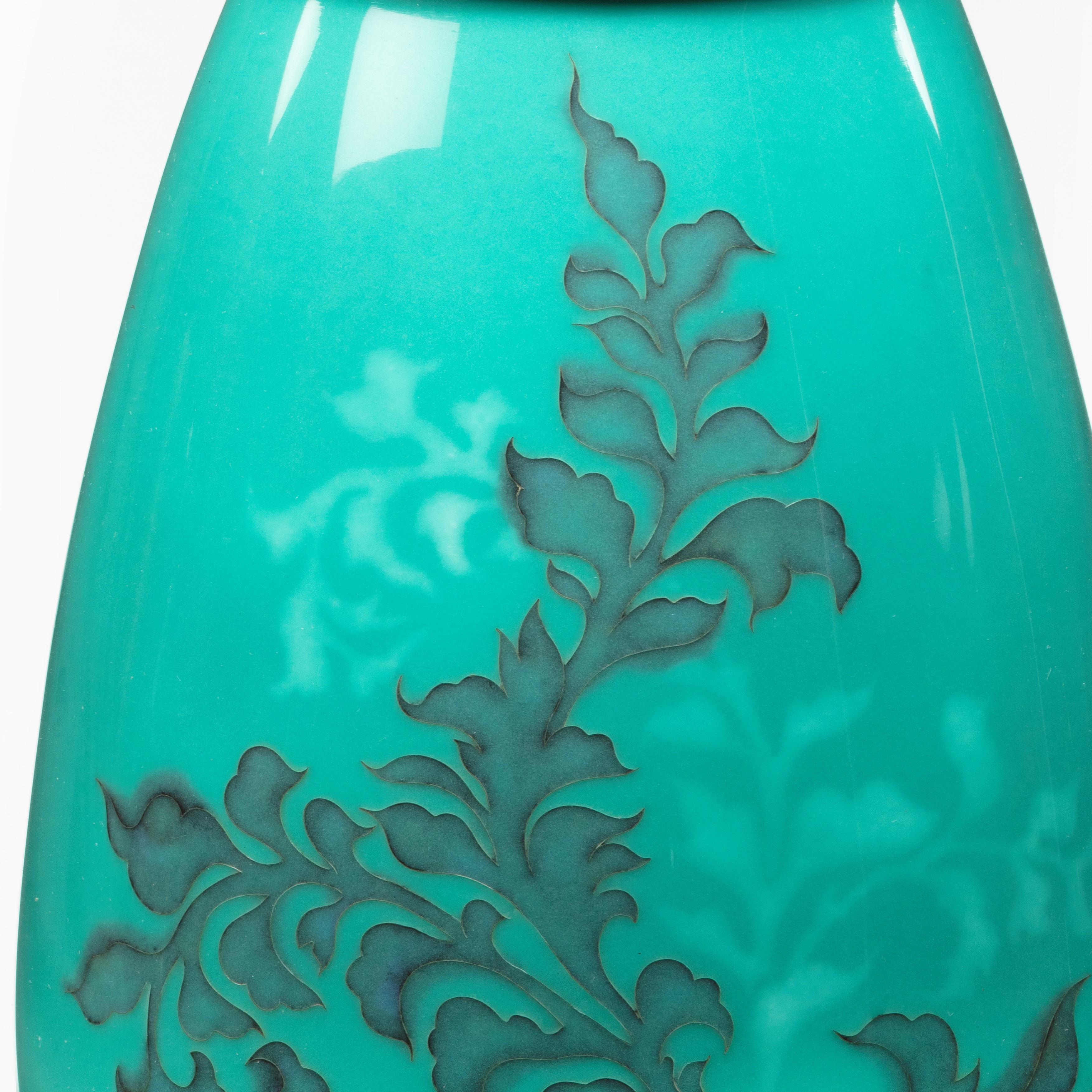 A Showa period cloisonné vase by Tamura, of ovoid form decorated with a spray of grey foliage with silver wires echoed by a similar spray in pale musen enamel, all on a turquoise ground, chrome mounts. Japanese, c1930.