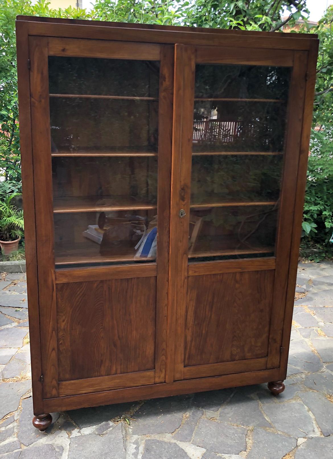 Showcase bookcase in Italian solid chestnut, original from 1930, with internal shelves.
Comes from an old country house in the Garfagnana area of Tuscany.
The paint is original in patina, honey amber color. 
As shown in the photographs and