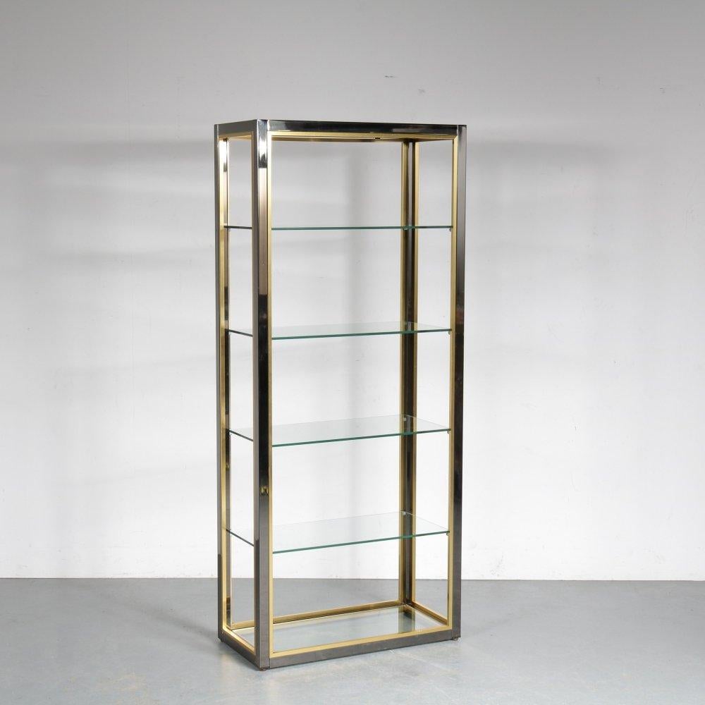 Display cabinet in chrome plated steel, brass and glass shelves. designed by Renato Zevi, 1970s, inspired by the Hollywood Regency style. Sophisticated self-supporting shelving unit in brass and chrome a solid frame, made in Italy, 1970s. The piece