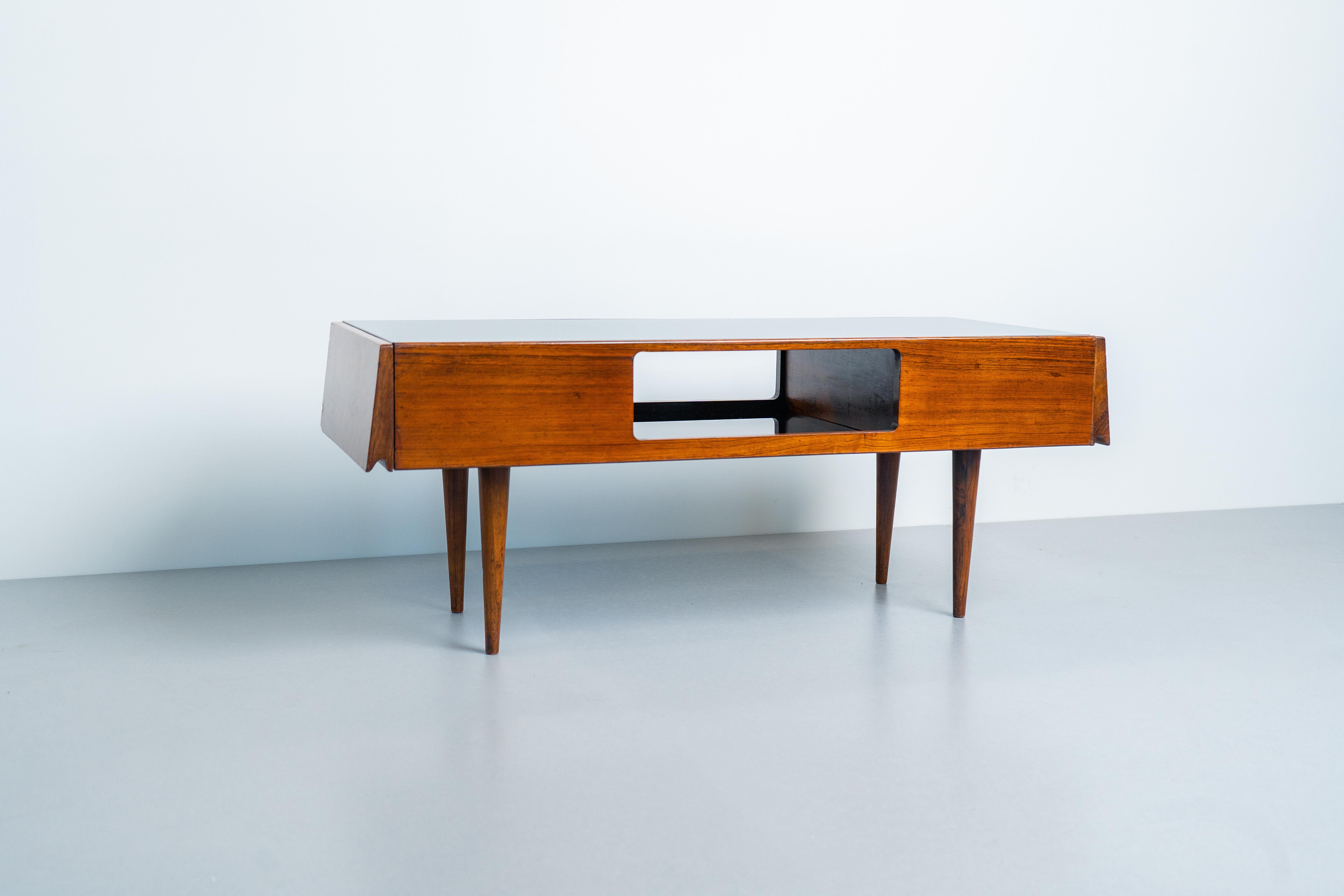Martin Eisler (1913-1977) designed this rosewood coffee table for Forma S.A. Móveis e Objetos de Arte. It belongs to a furniture category commonly found during the midcentury period and extensively produced by Forma: the showcase table.
The coffee