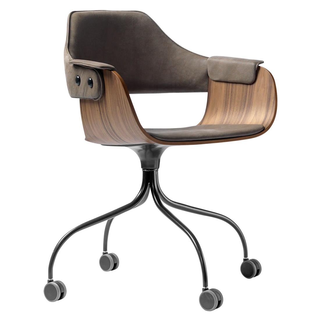 Upholstered desk chair in walnut and leather on casters. 
