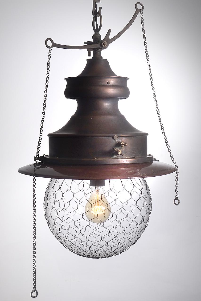 This is a unique copper bodied lamp with nice detail. I love the long are rocker gas valve with chains and the 12 inch diameter wire cage globe. This is the type of fixture that was often used in turn-of-century a general stores.